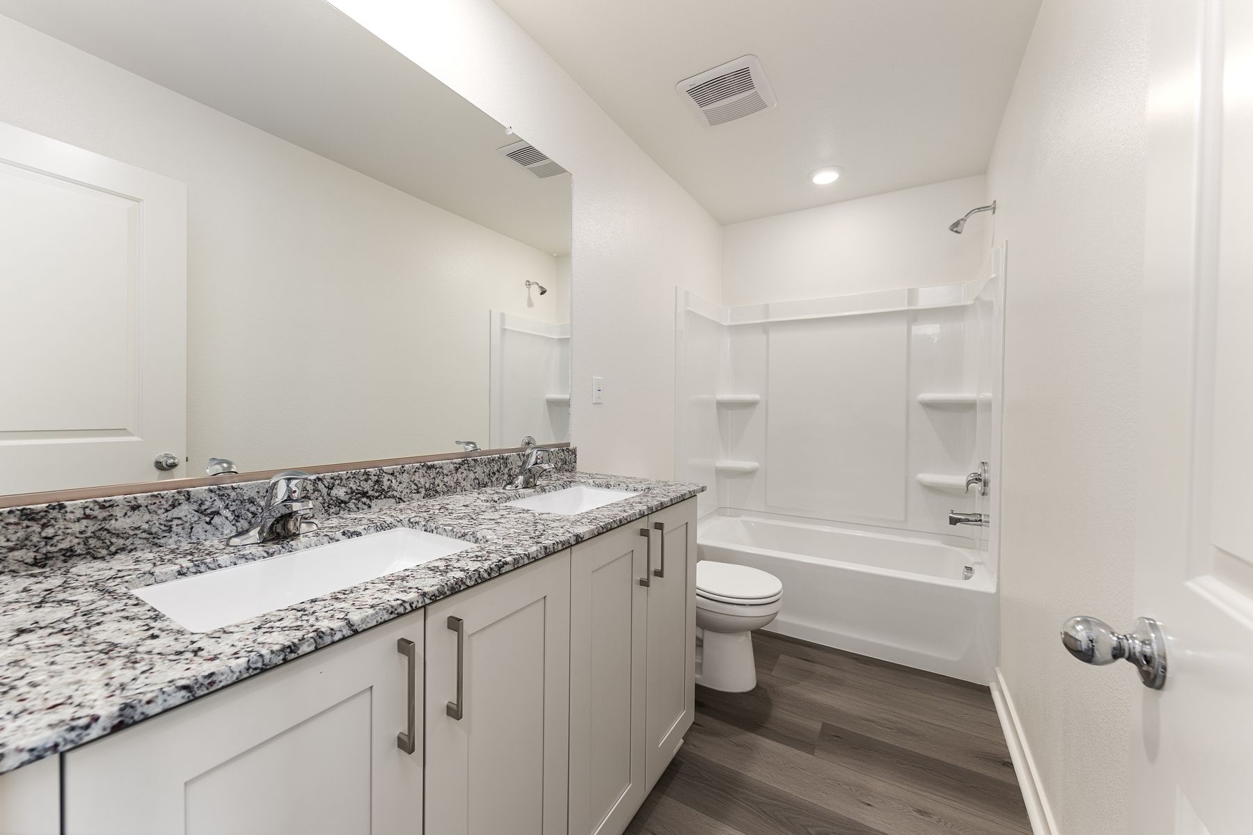 The secondary bathroom has a dual vanity and tub/shower combo.