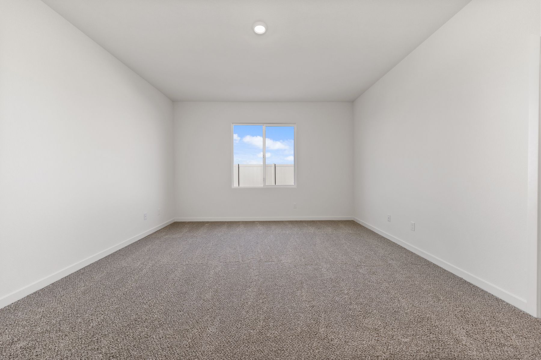 The master bedroom has a large window and is spacious.
