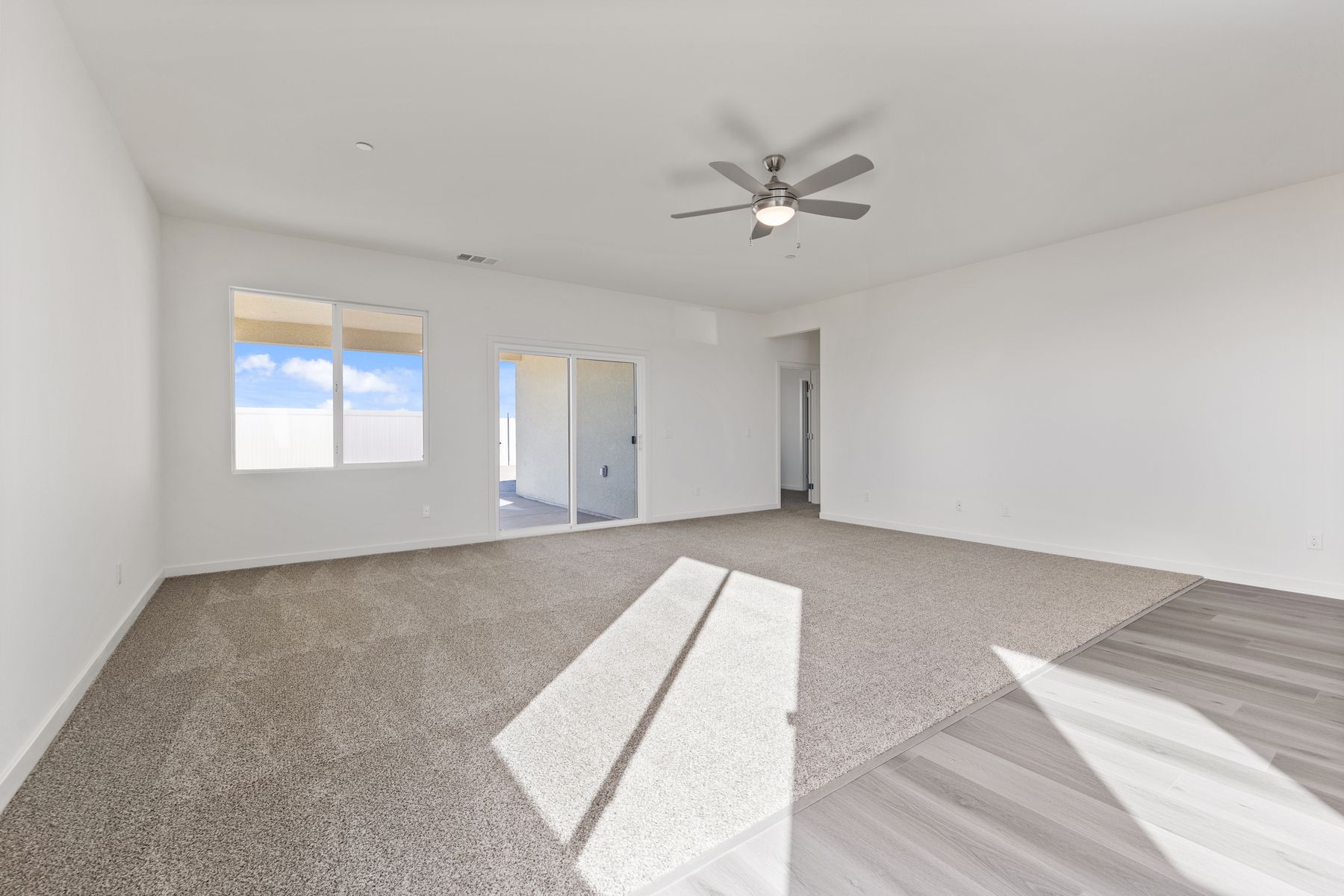 The family room is off of the kitchen and has a ceiling fan.