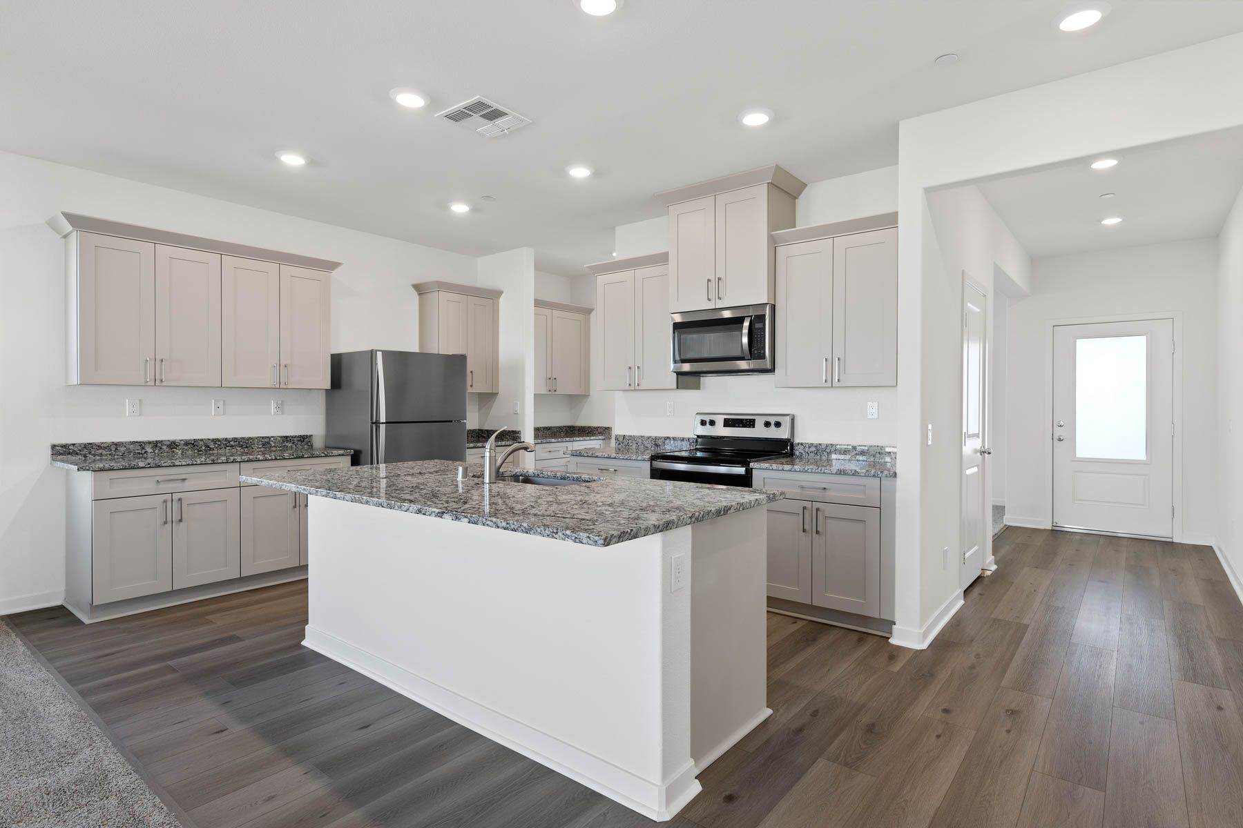 The chef ready kitchen has plank flooring and stainless steel appliances.
