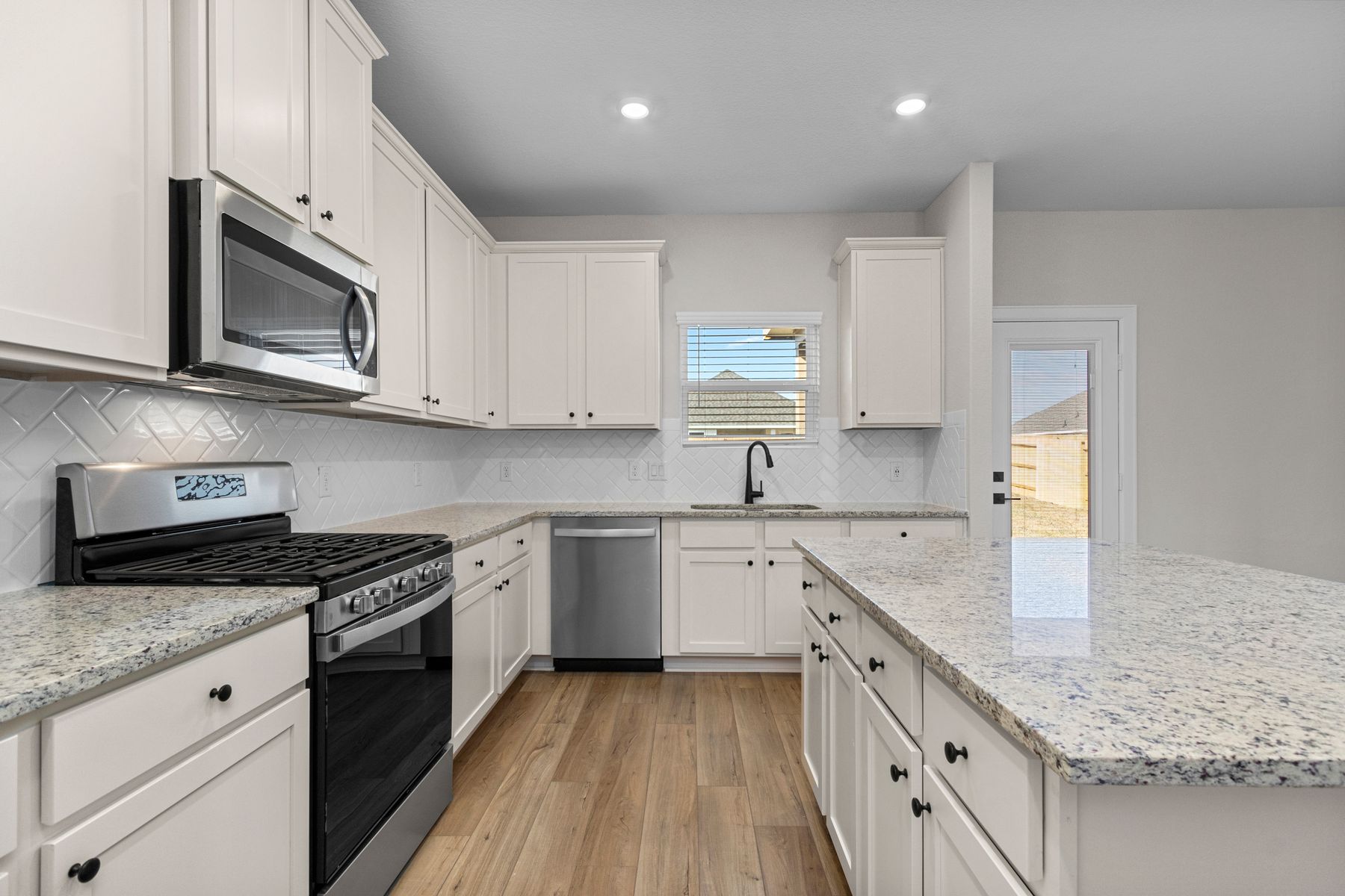 Enjoy stunning granite countertops and designer wood cabinetry in this kitchen.