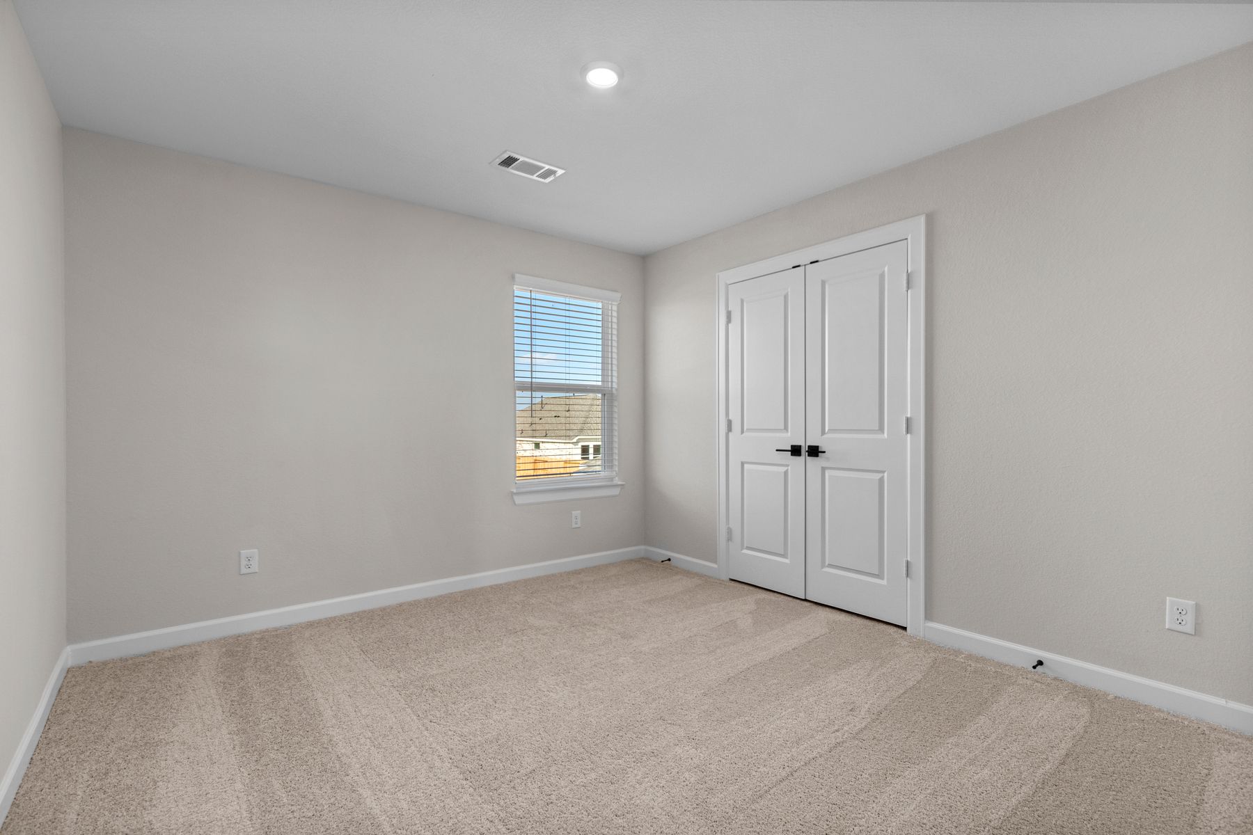 Windows let in plenty of light to this secondary bedroom.