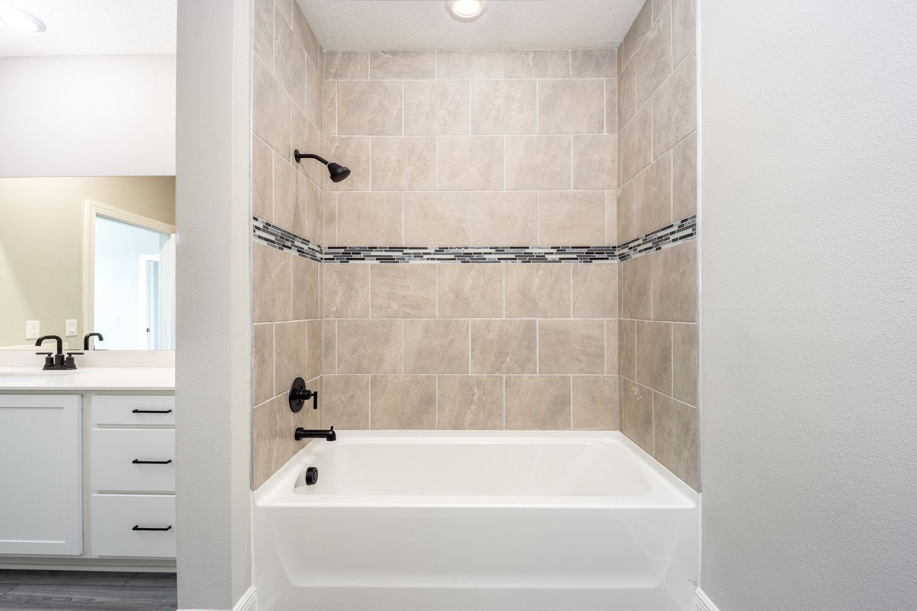 This master bathroom has a combination shower tub with a beautiful tile wall.