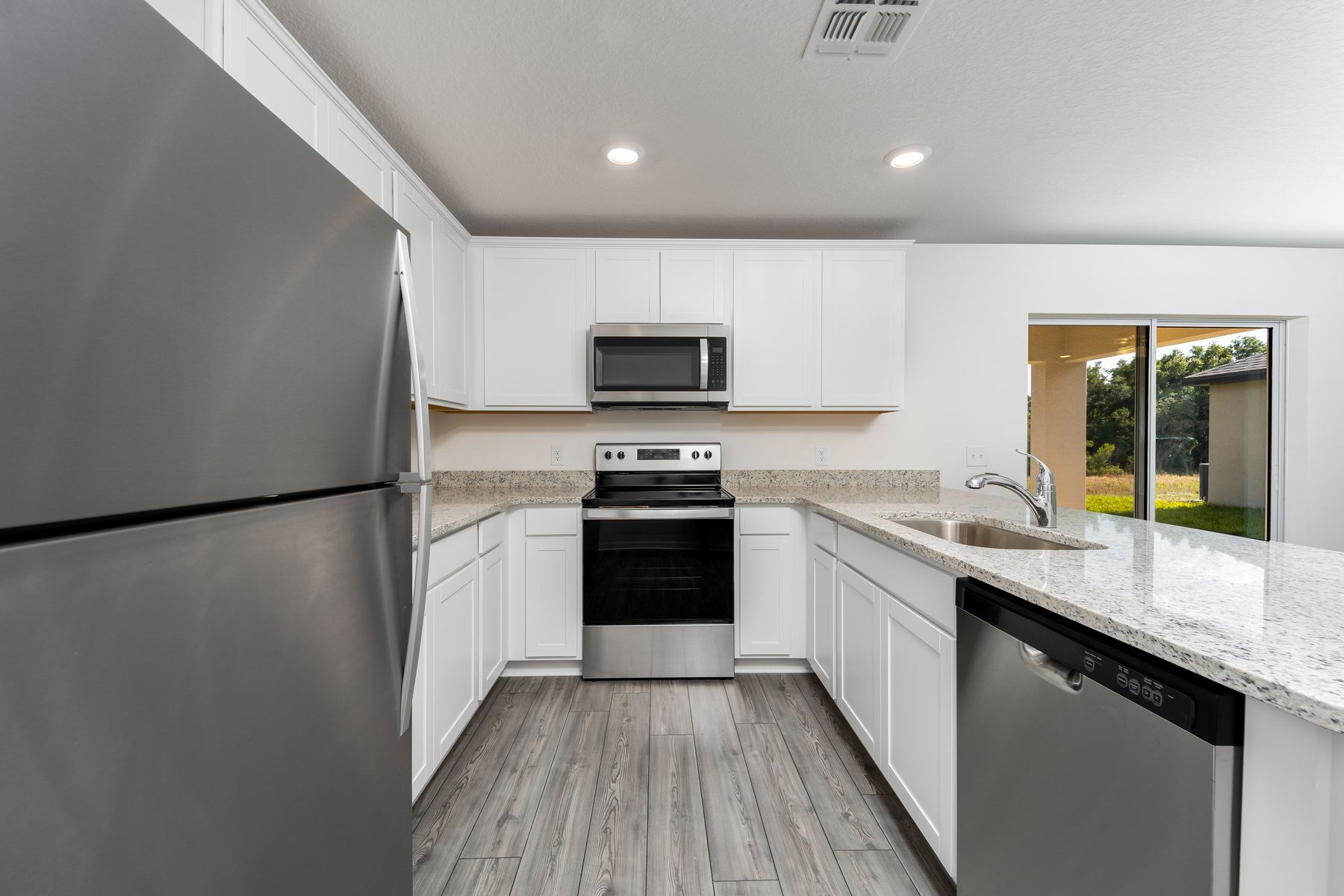 The kitchen features stainless steel appliances and granite countertops.