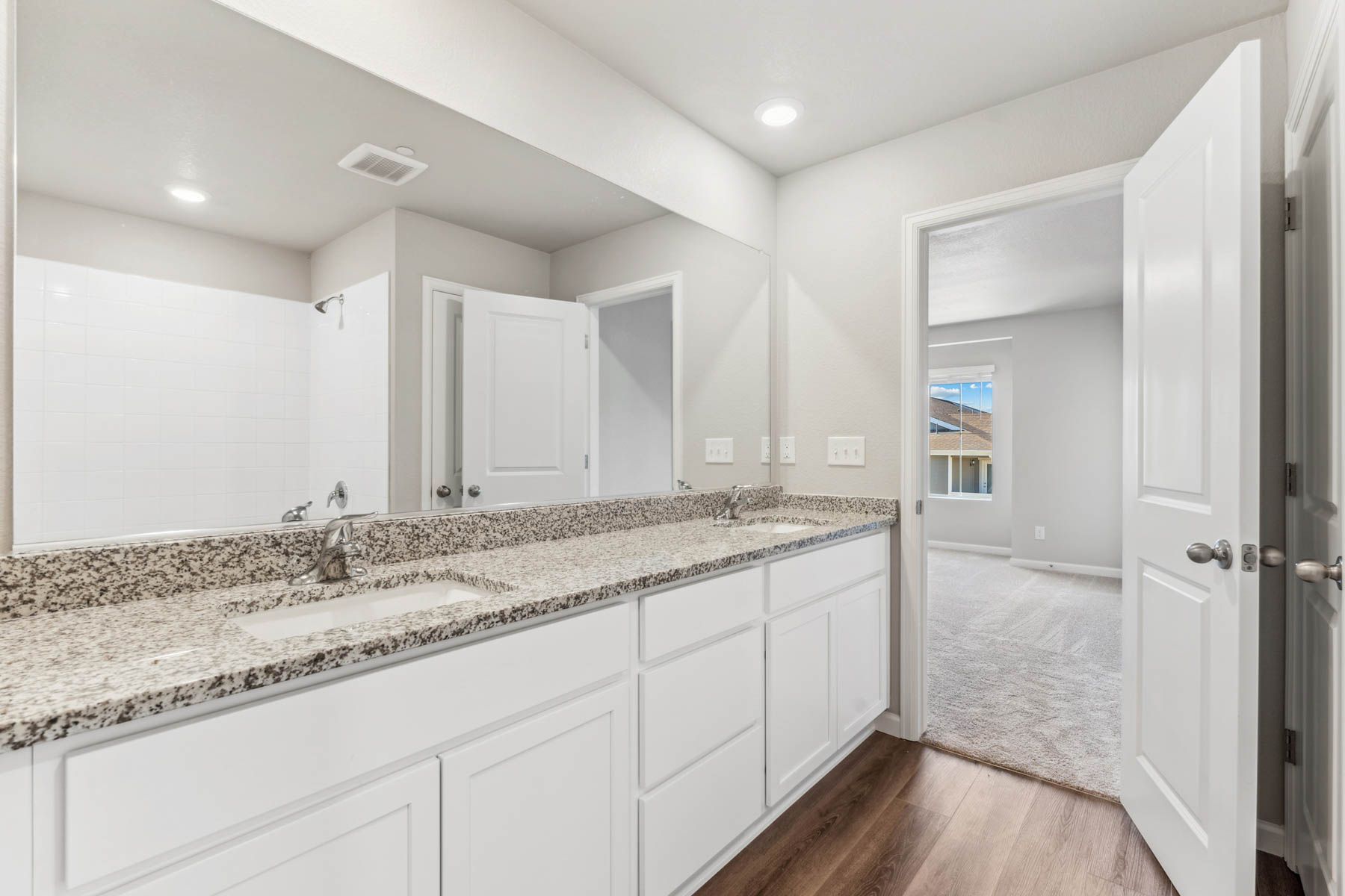 The master bathroom has a spacious dual sink vanity with a tub shower combo.