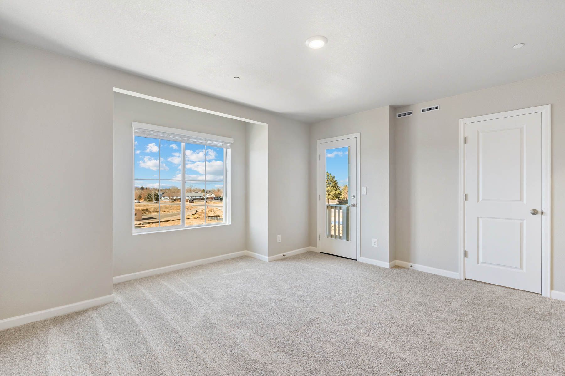 The master bedroom is spacious with a large window.