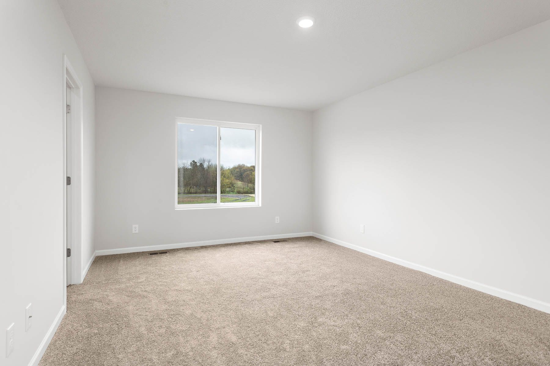 The master bedroom is spacious with a large window.