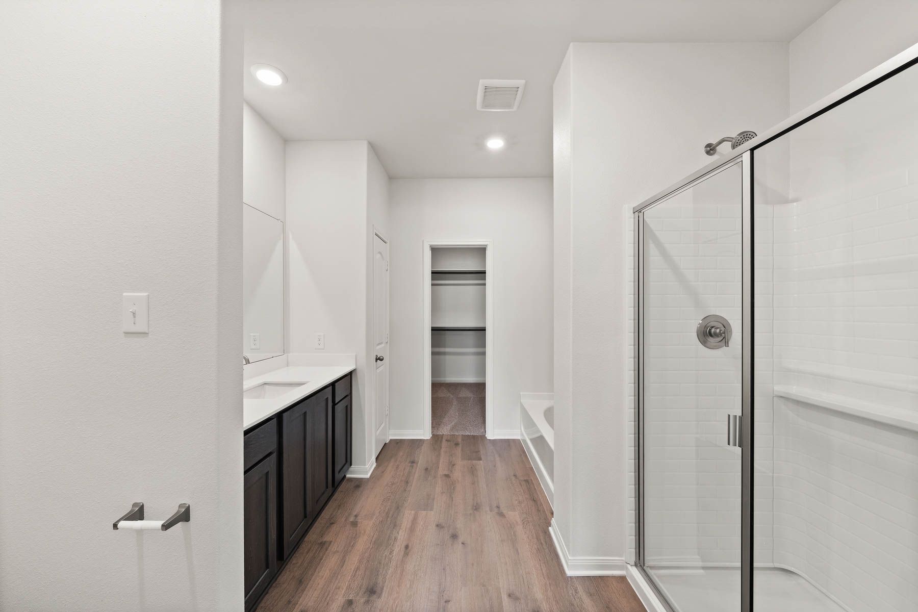 The master bathroom has a large walk-in, glass shower and a garden tub.