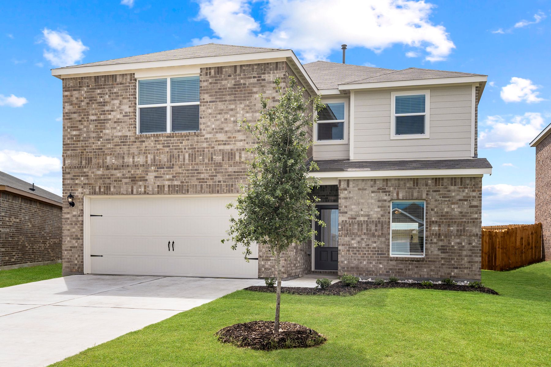 The Driftwood is a beautiful two-story, brick home with siding details.