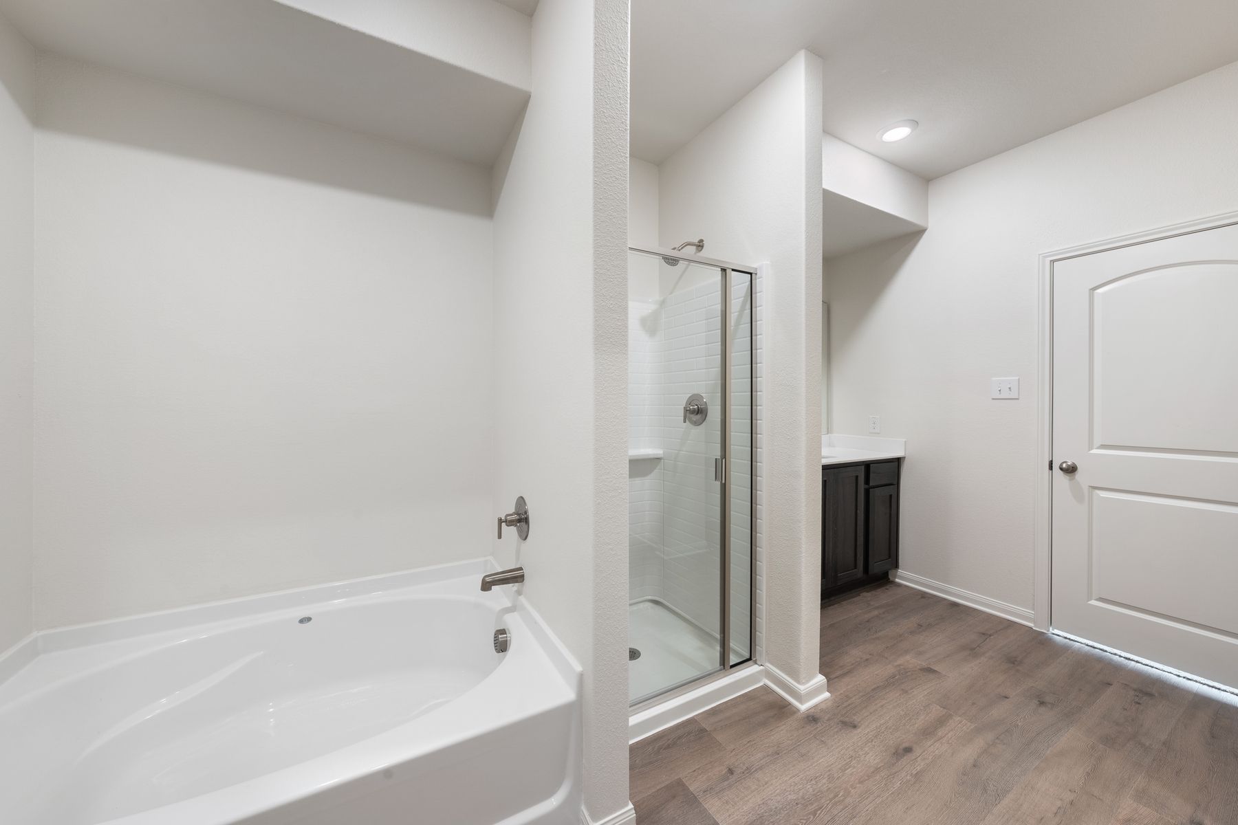 The master bathroom has a large walk-in, glass shower and a garden tub.