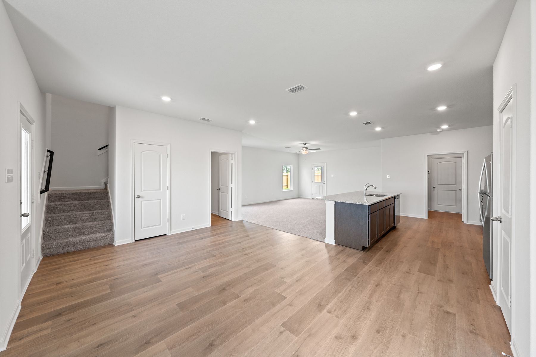 The open-concept layout of this floor plan has the kitchen, family room and dining room sitting next to one another.
