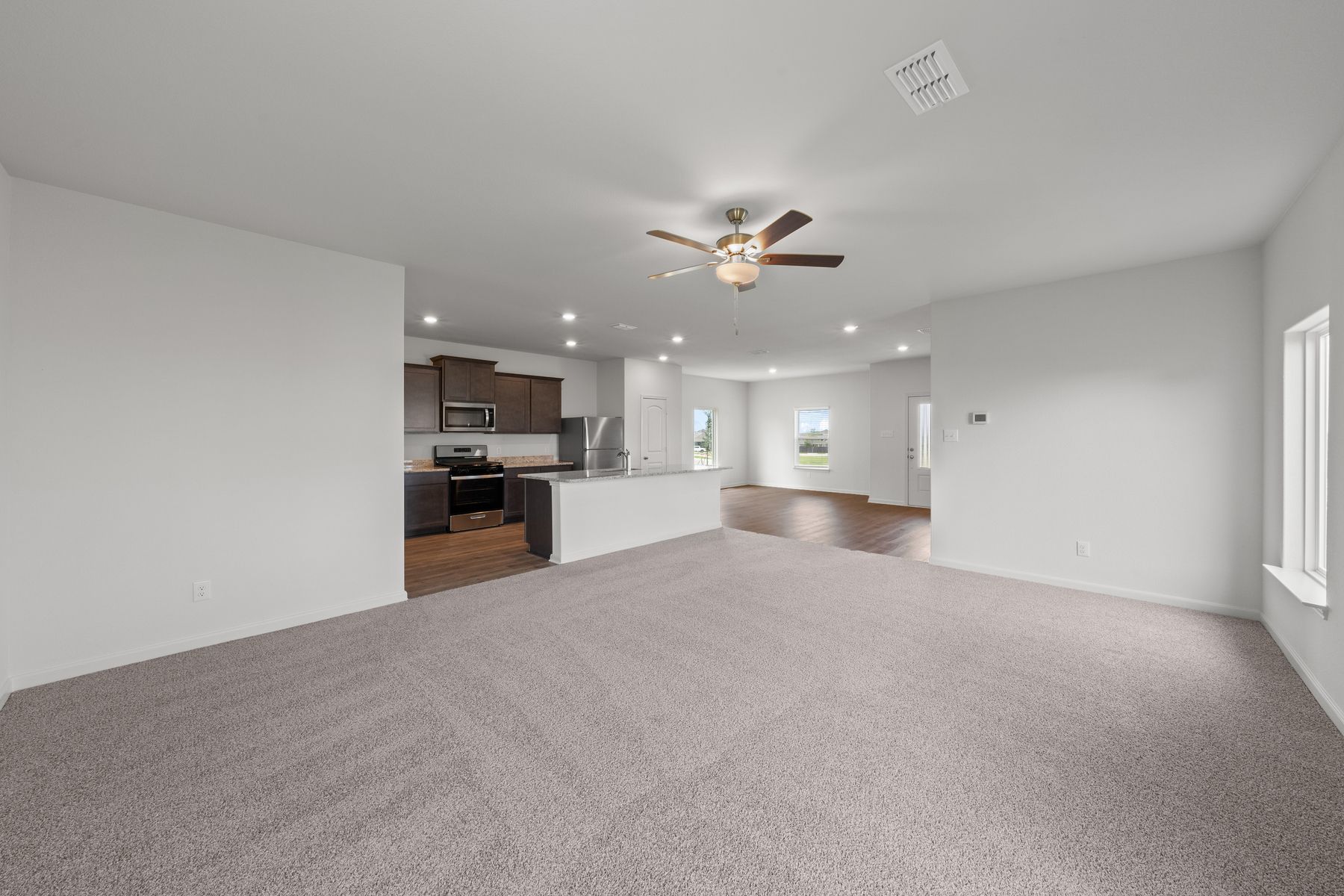 The open-concept layout of this floor plan has the kitchen, family room and dining room sitting next to one another.
