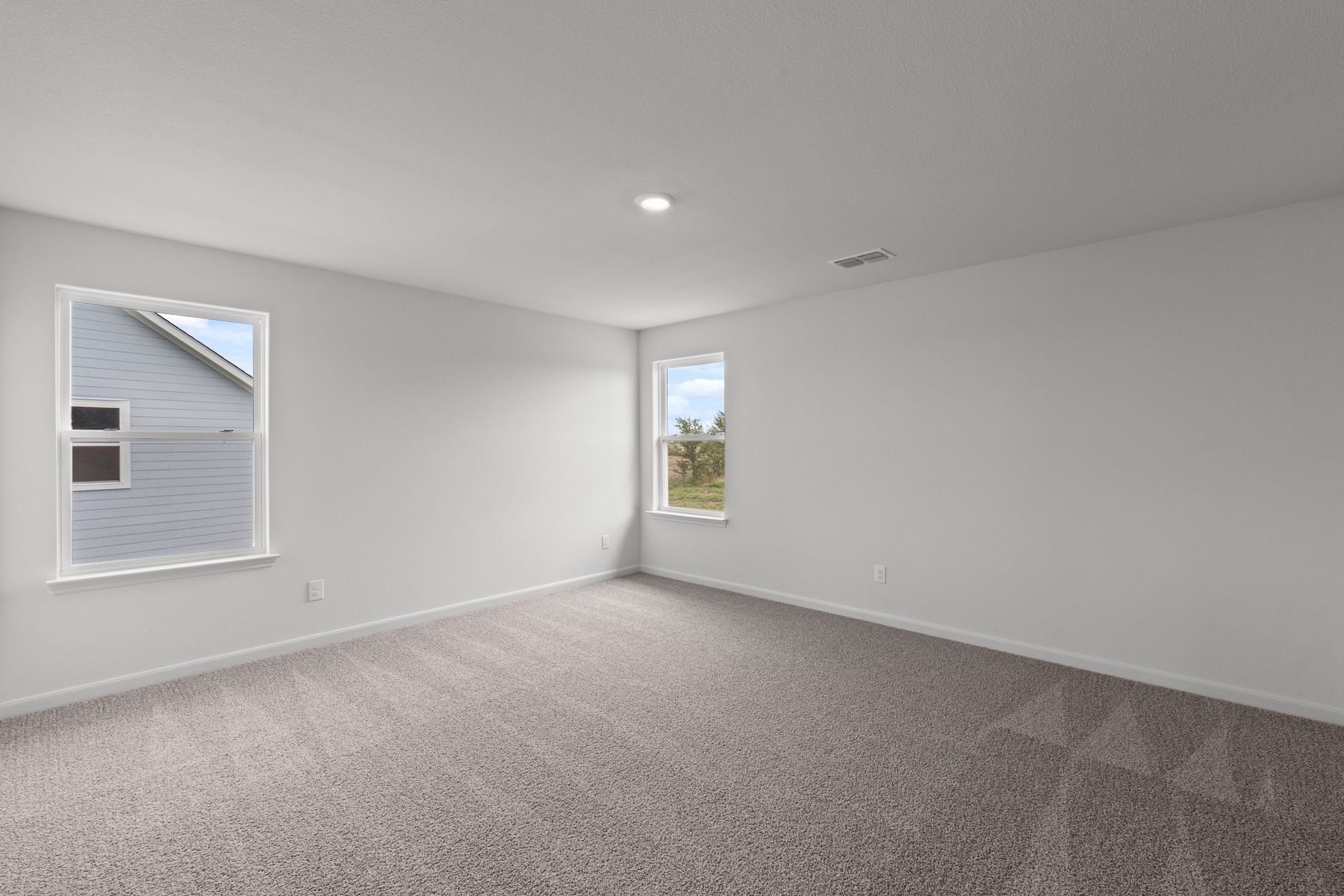 The spacious master bedroom has two windows that lets in natural light and backyard views.