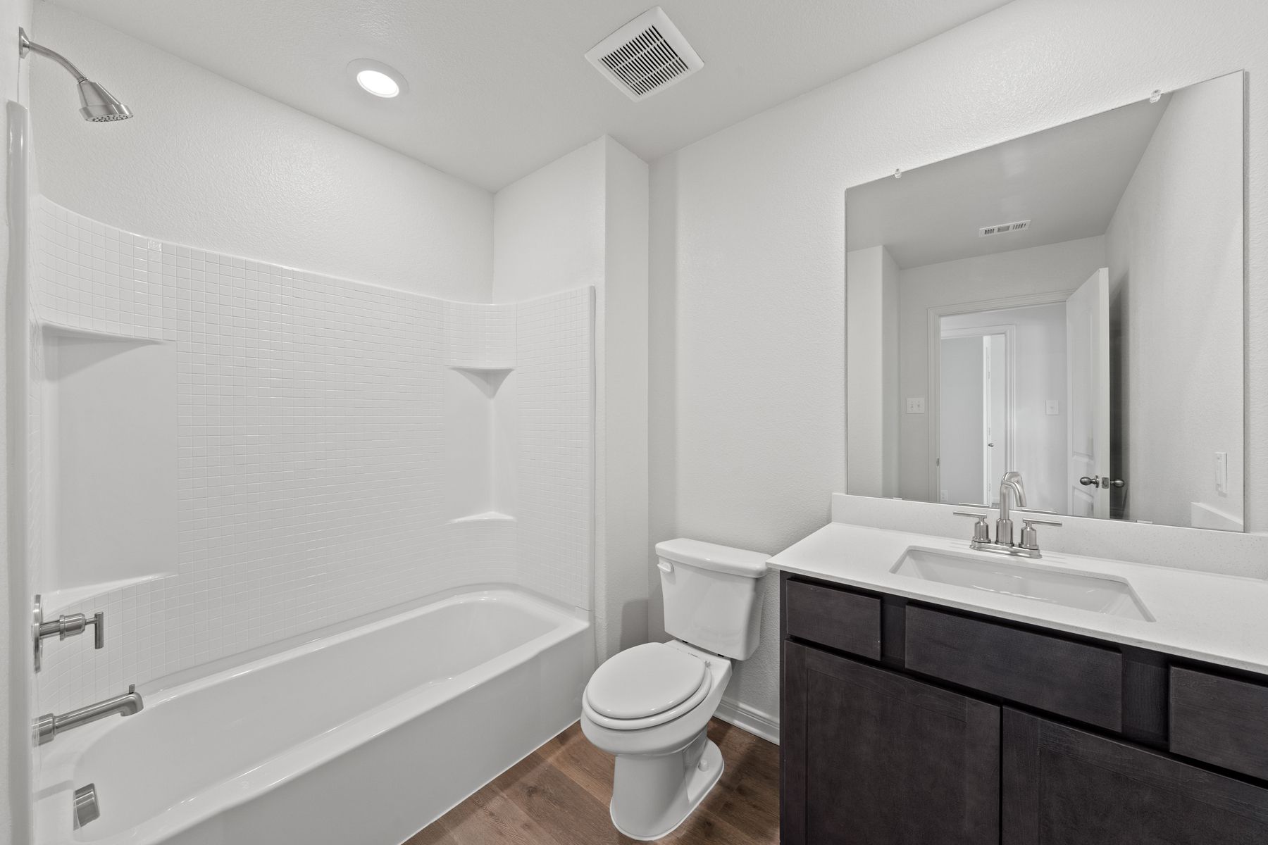 The secondary bathroom has a large vanity space and a shower-tub combo.