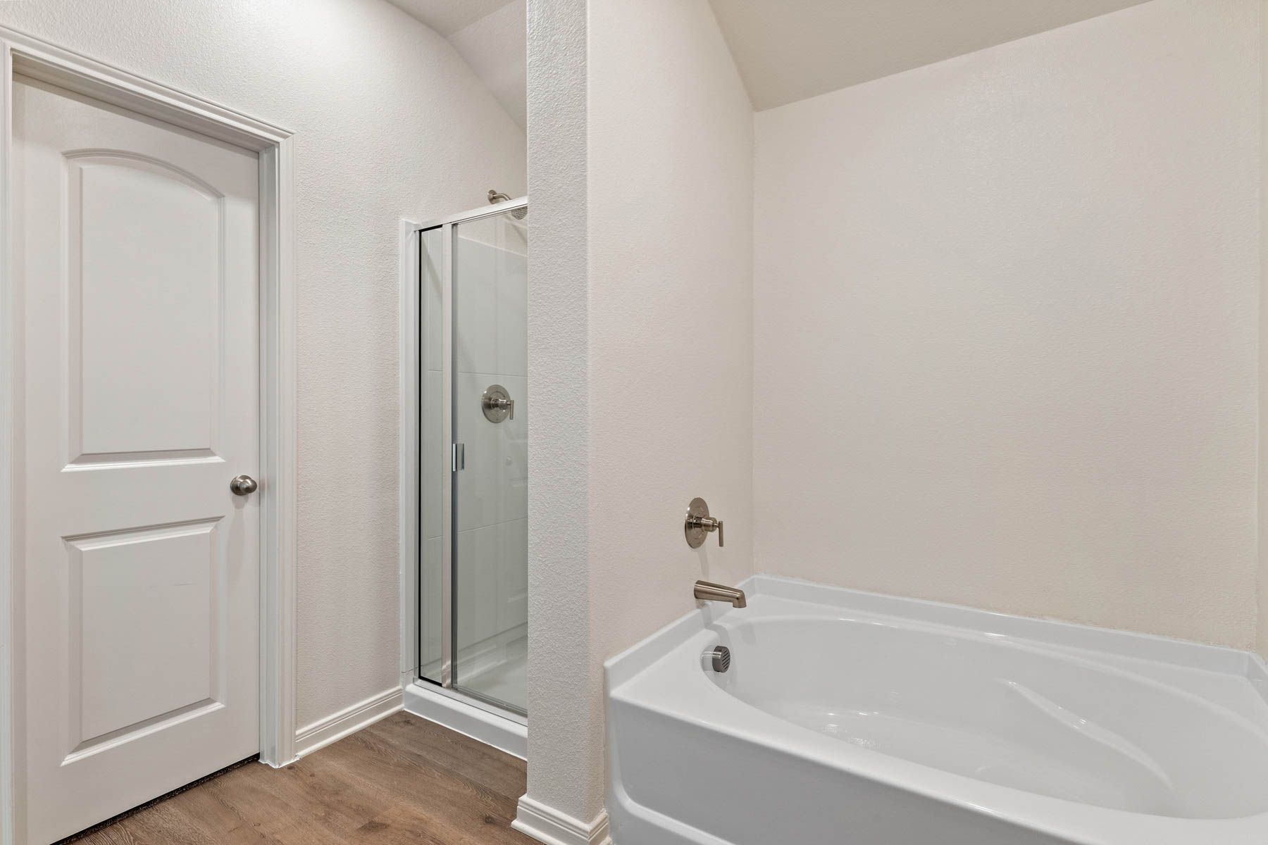 The master bathroom has a large glass, walk-in shower and garden tub.