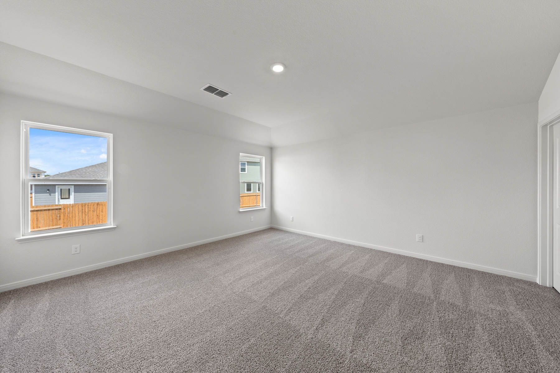 The spacious master bedroom has a large window that lets in natural light and backyard views.