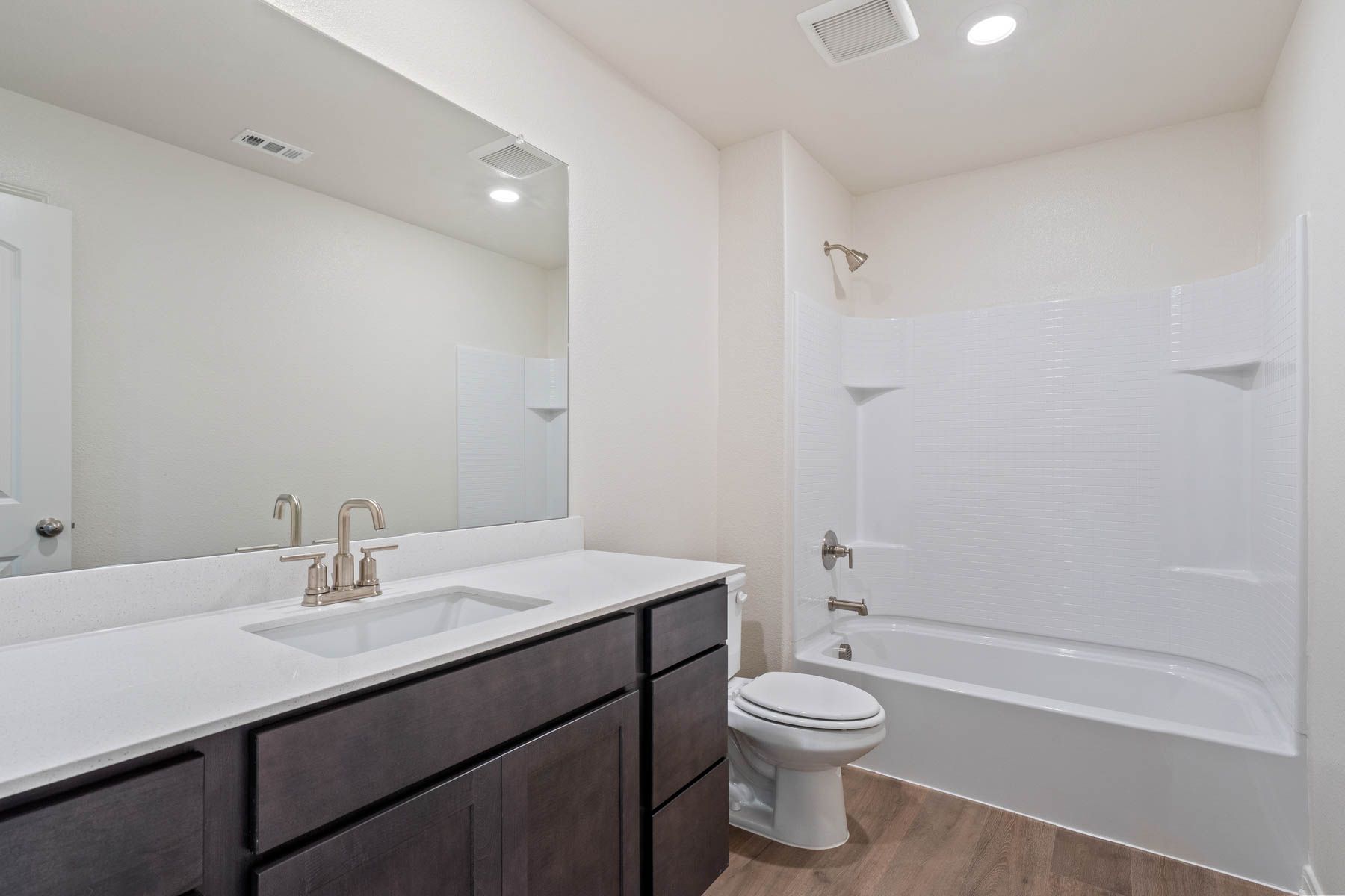 The secondary bathroom has a large vanity space and a shower-tub combo.