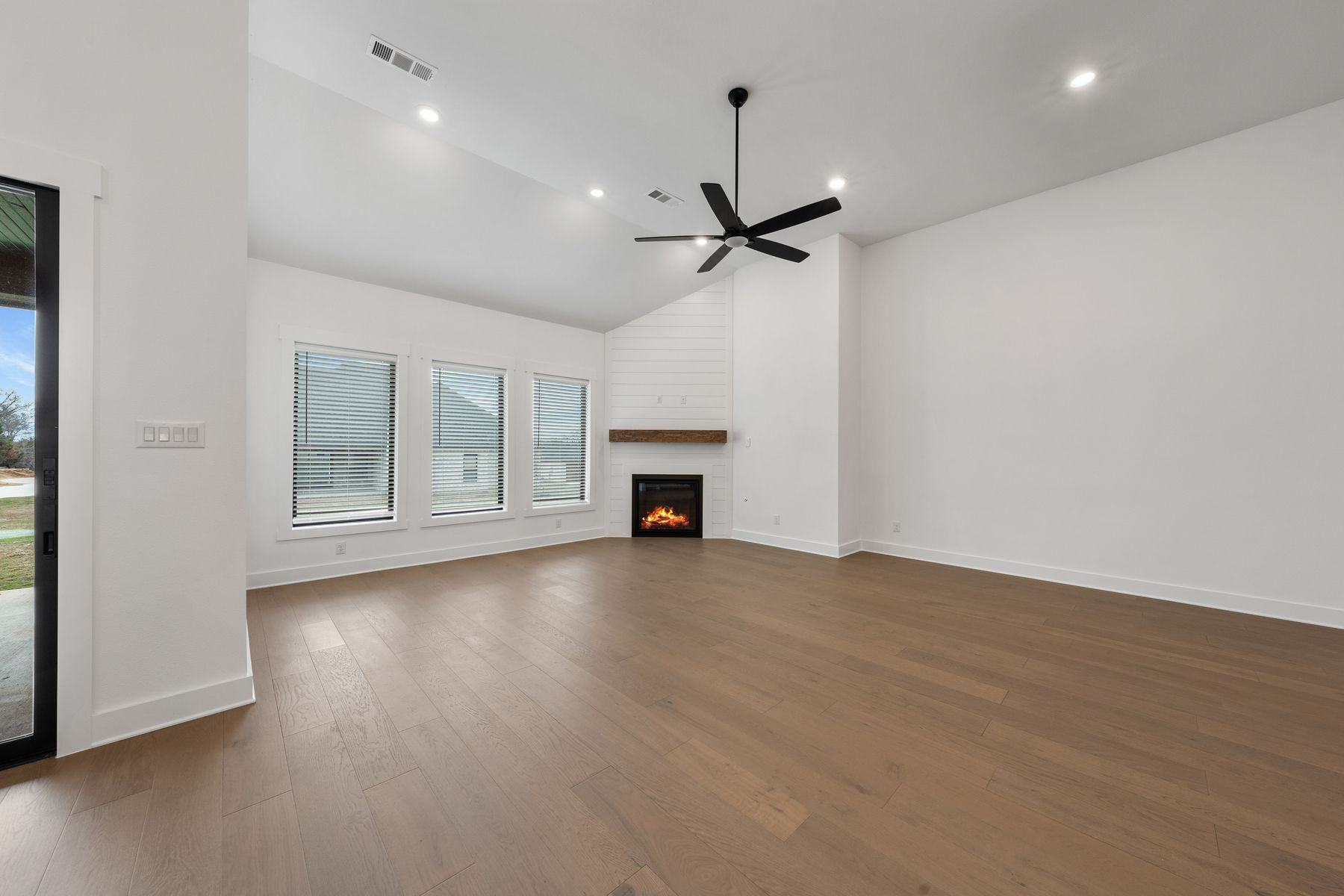 The spacious family room has large windows and an electric fireplace.