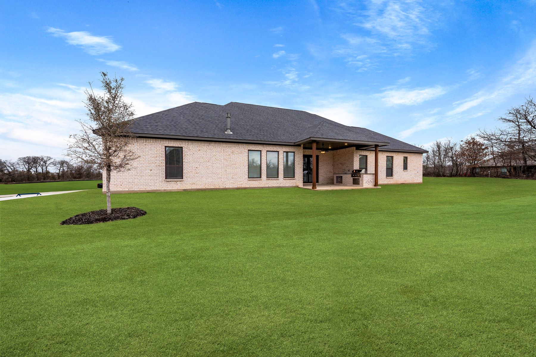 The Bradley II has a gorgeous back yard that includes a covered patio with an outdoor kitchen.