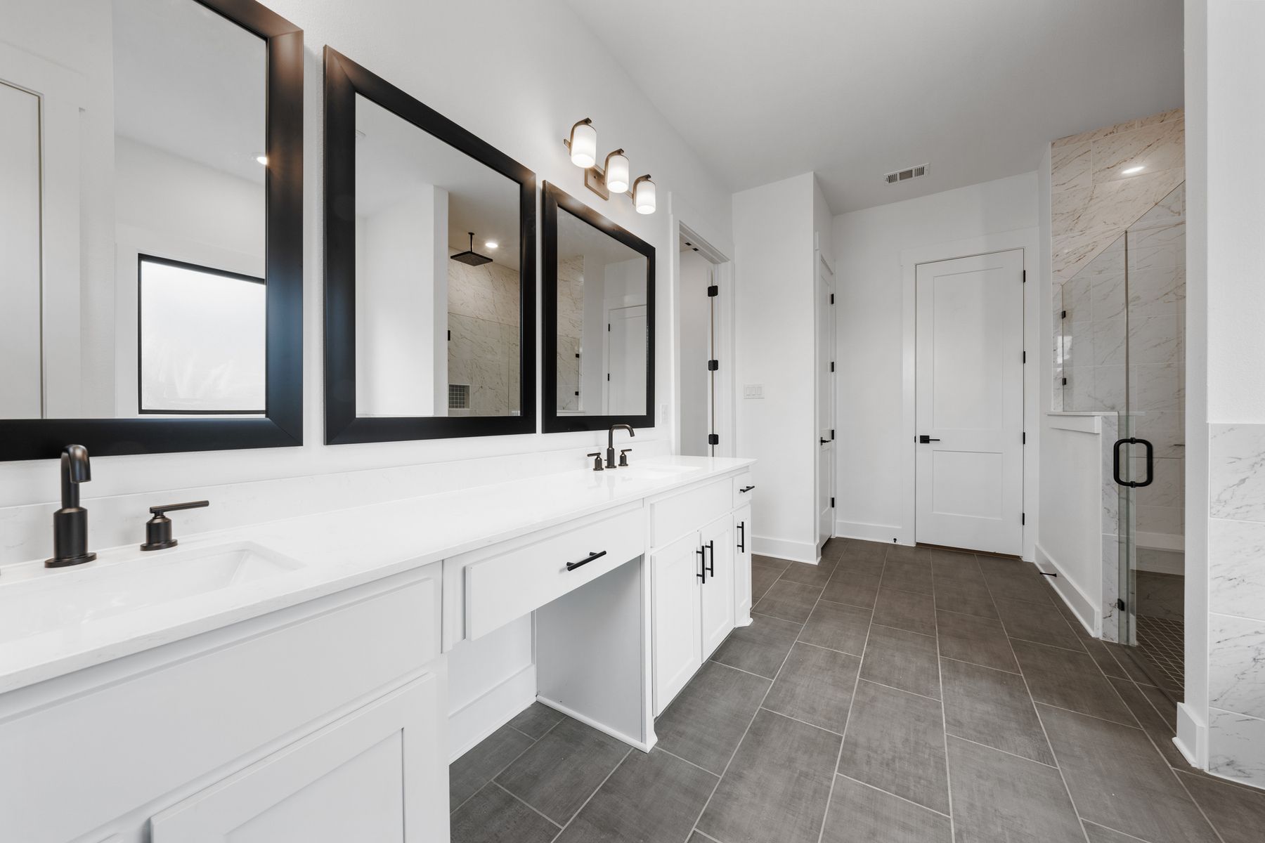 The gorgeous master bathroom has a giant vanity space that has two sinks and vanity space.