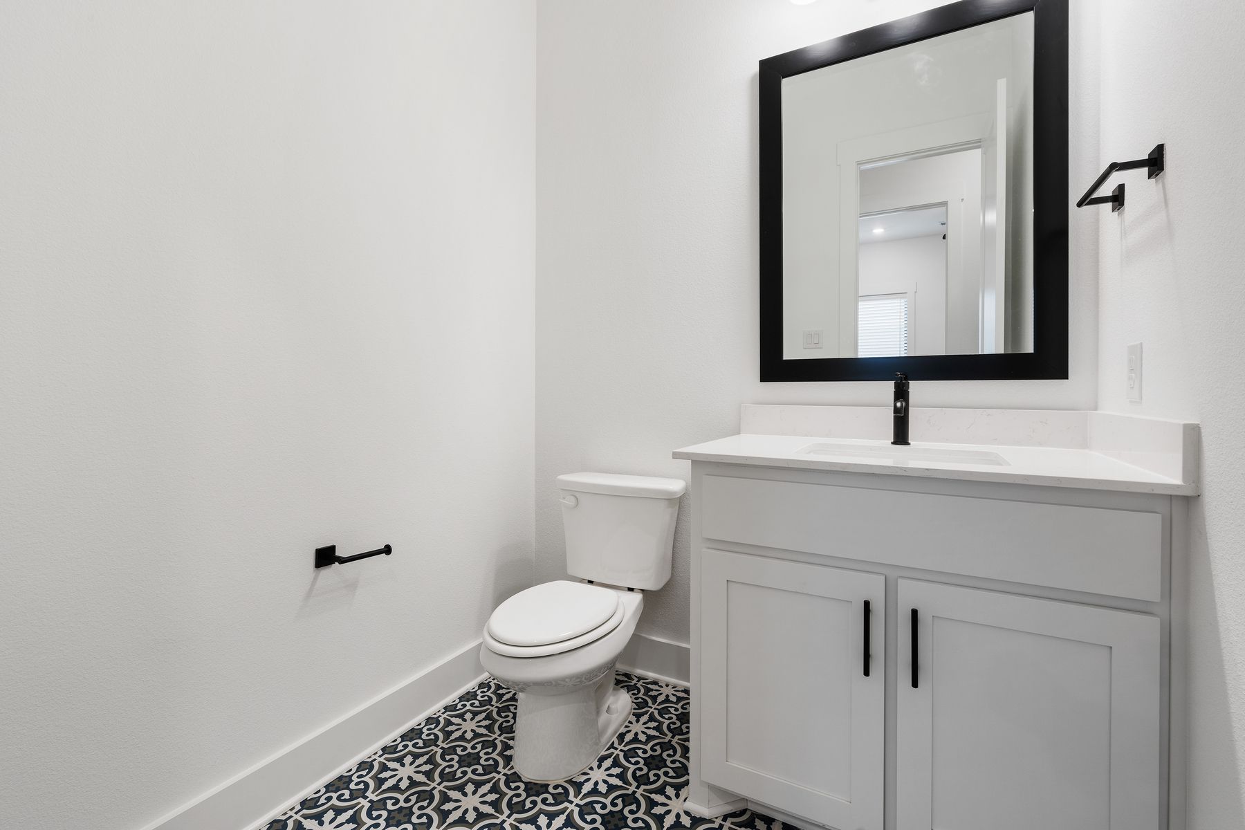 The half bathroom has gorgeous tile flooring.