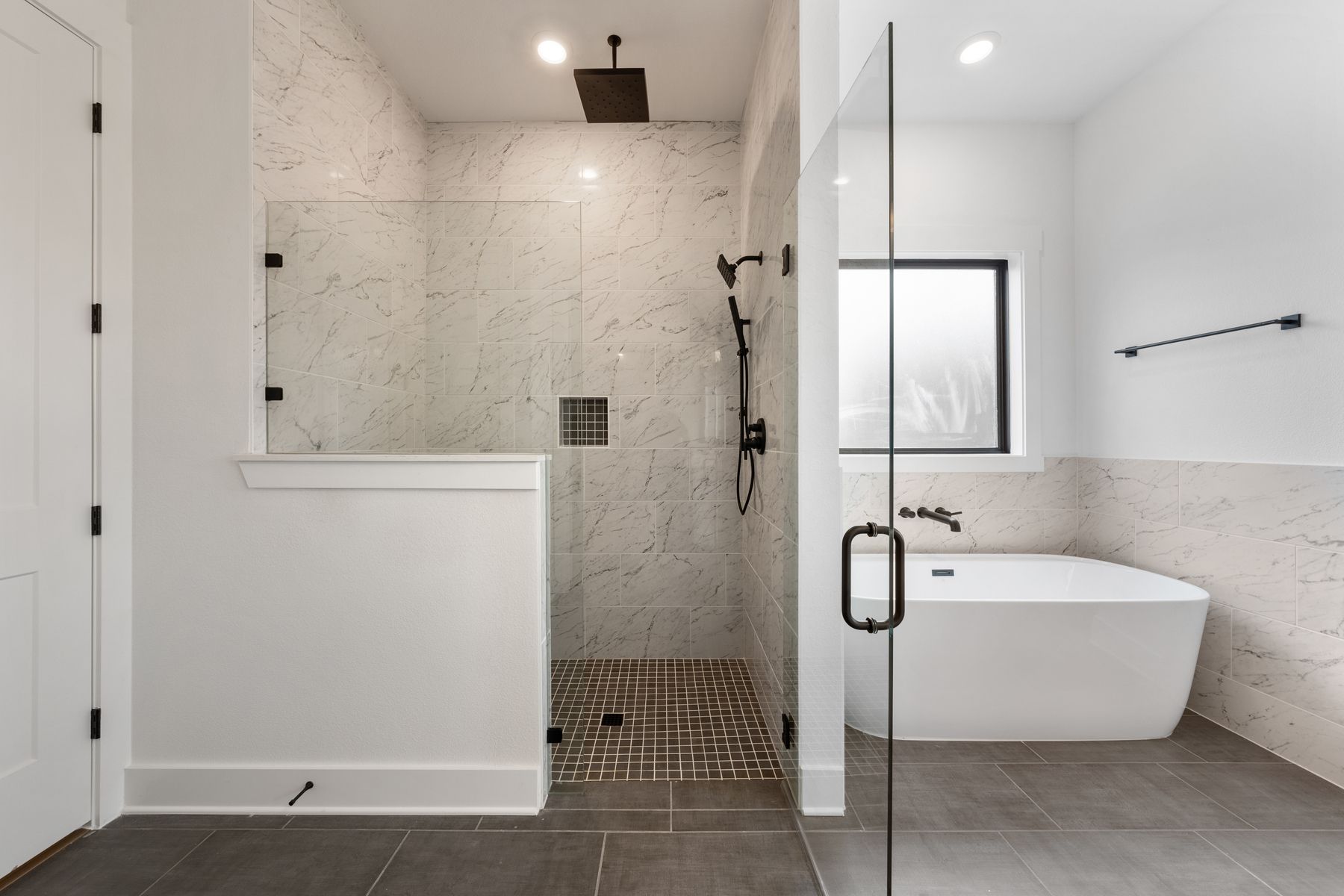 The gorgeous master bathroom has a large glass, walk-in shower and tub.