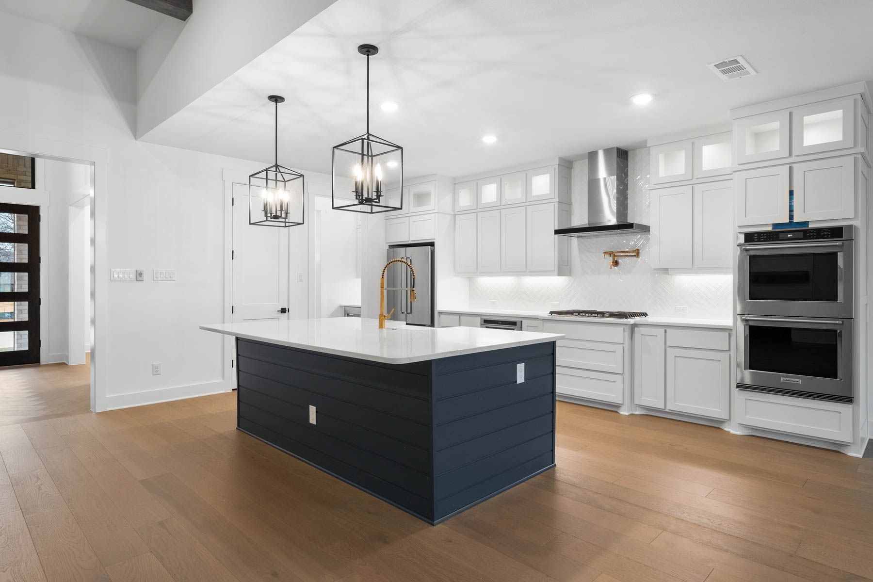 The kitchen has a beautiful blue island with quartz countertops.