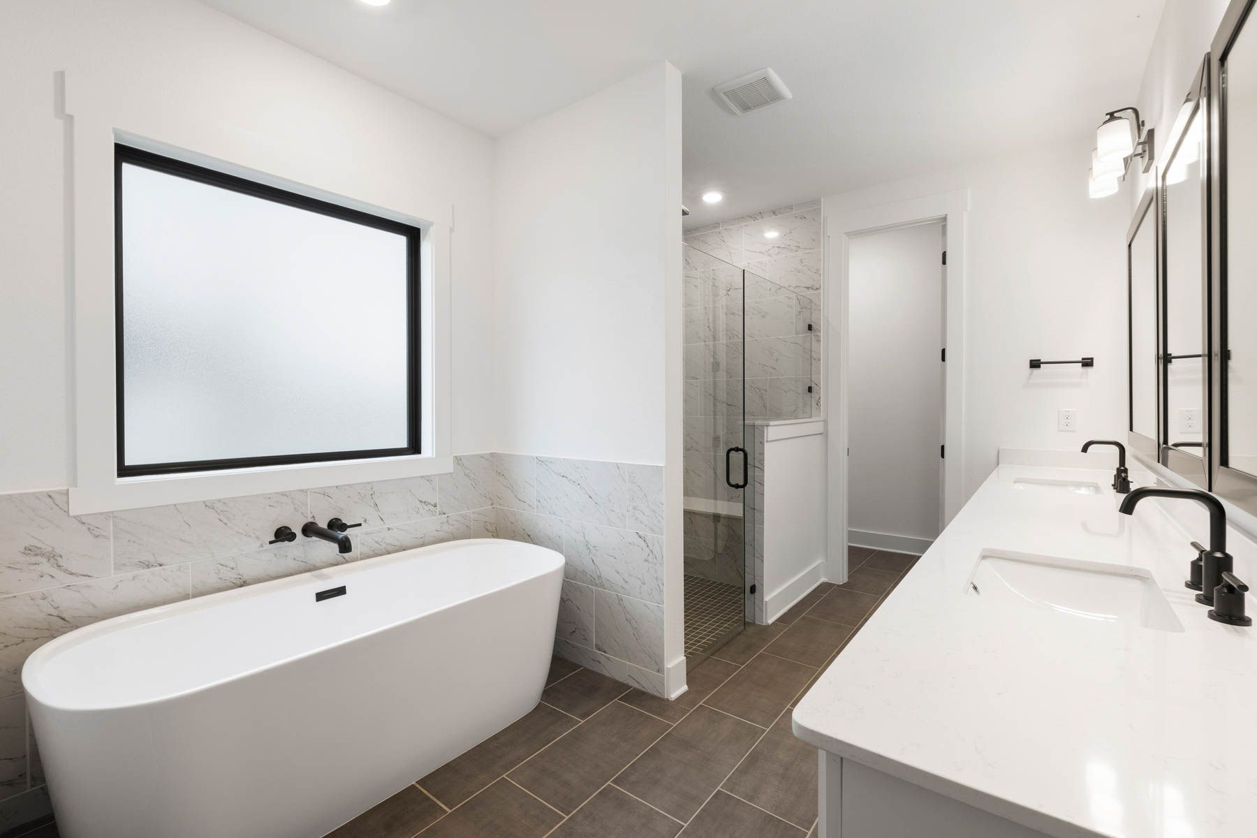 The gorgeous master bathroom has a large glass, walk-in shower and tub.