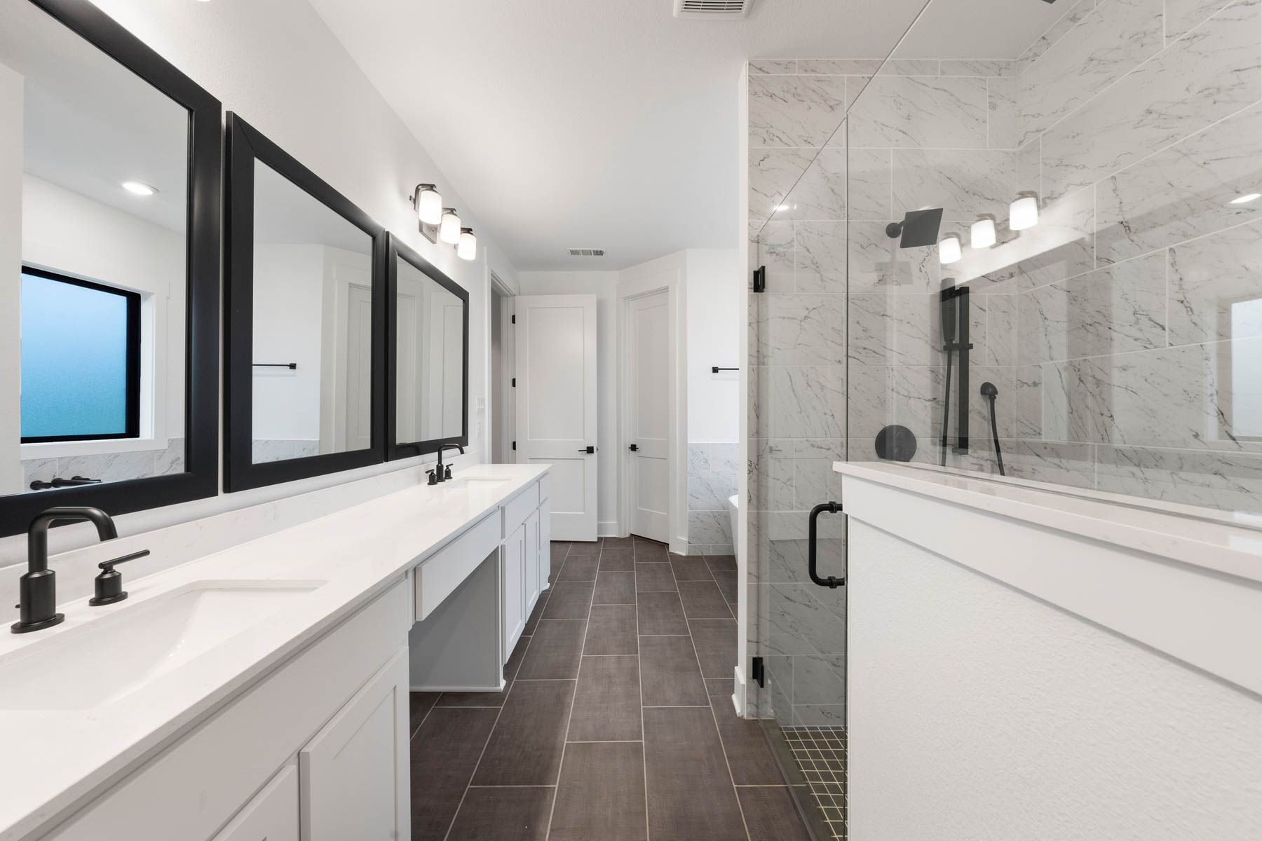 The gorgeous master bathroom has a giant vanity space that has two sinks and vanity space.