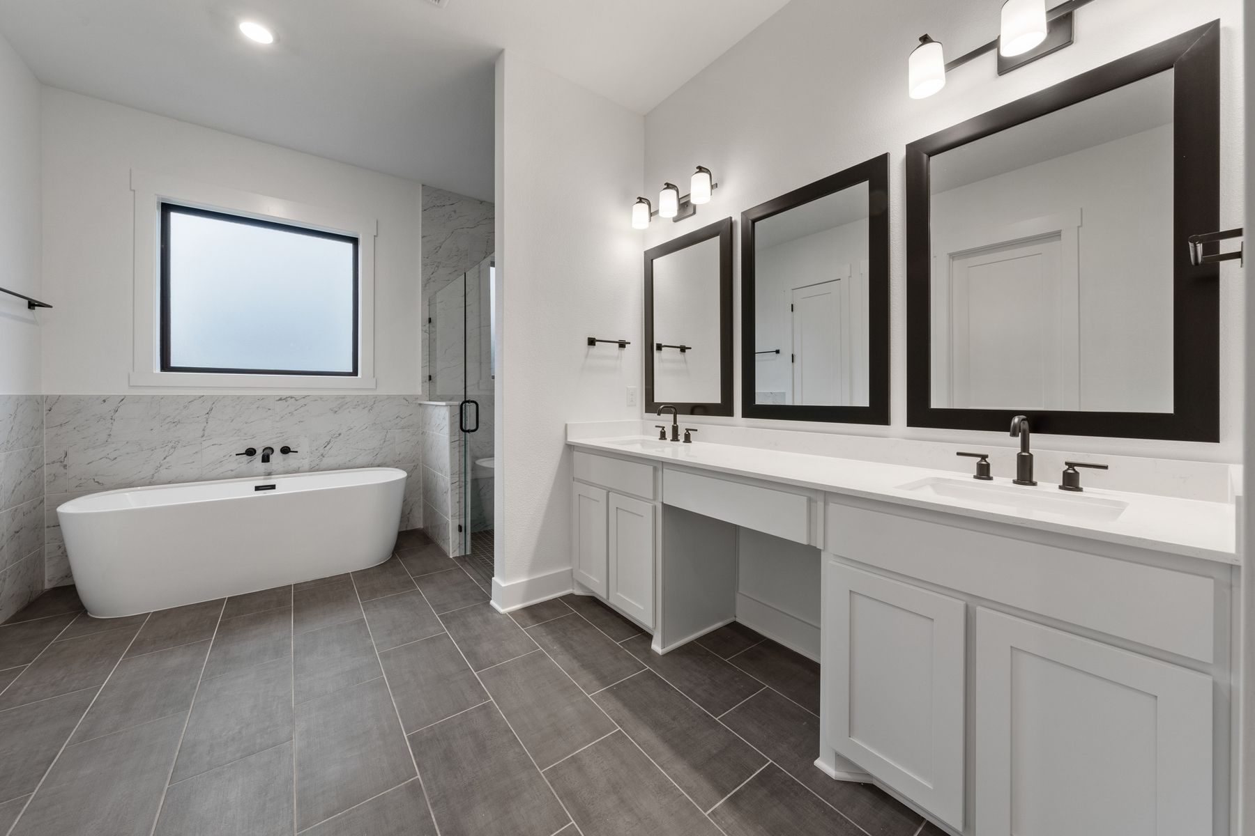 The gorgeous master bathroom has a giant vanity space that has two sinks and vanity space.