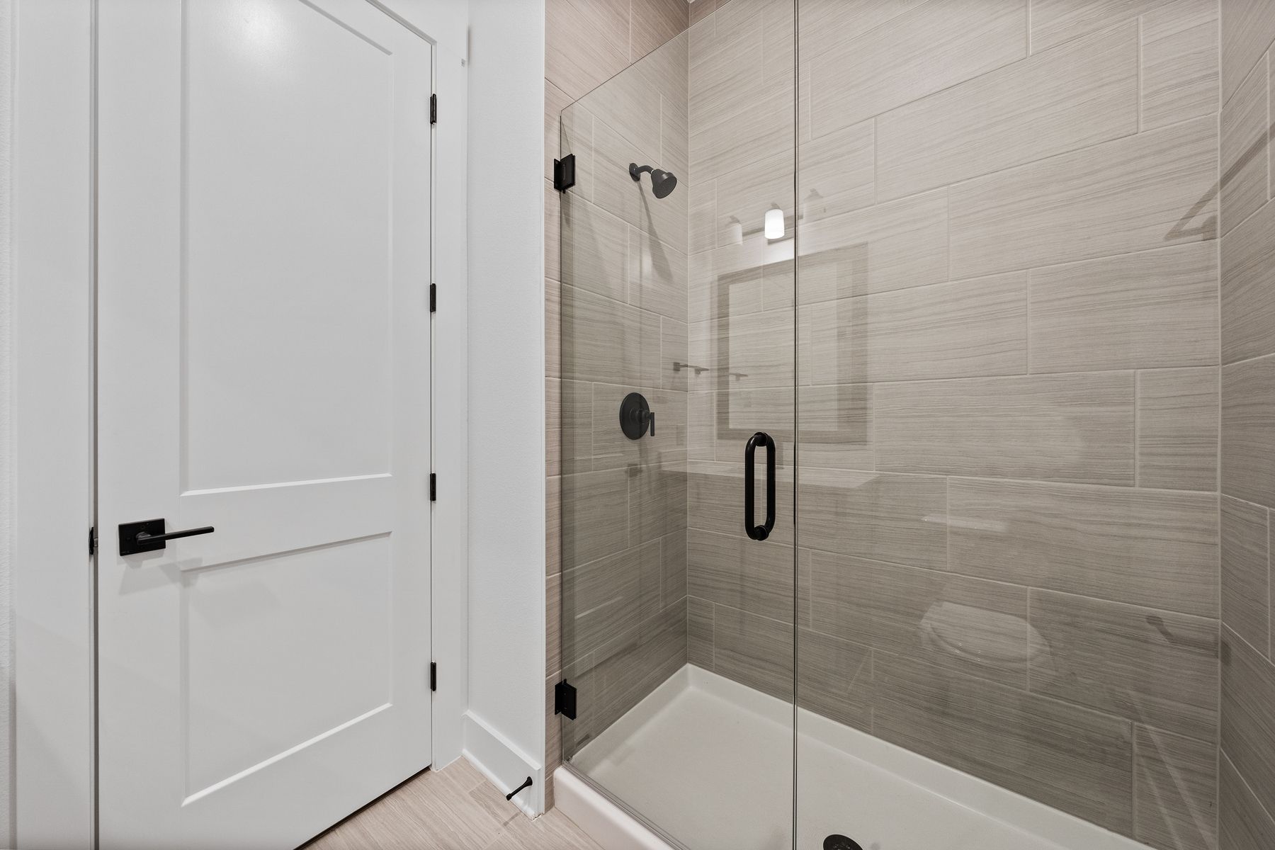 The secondary bathroom has a large vanity and glass, walk-in shower.