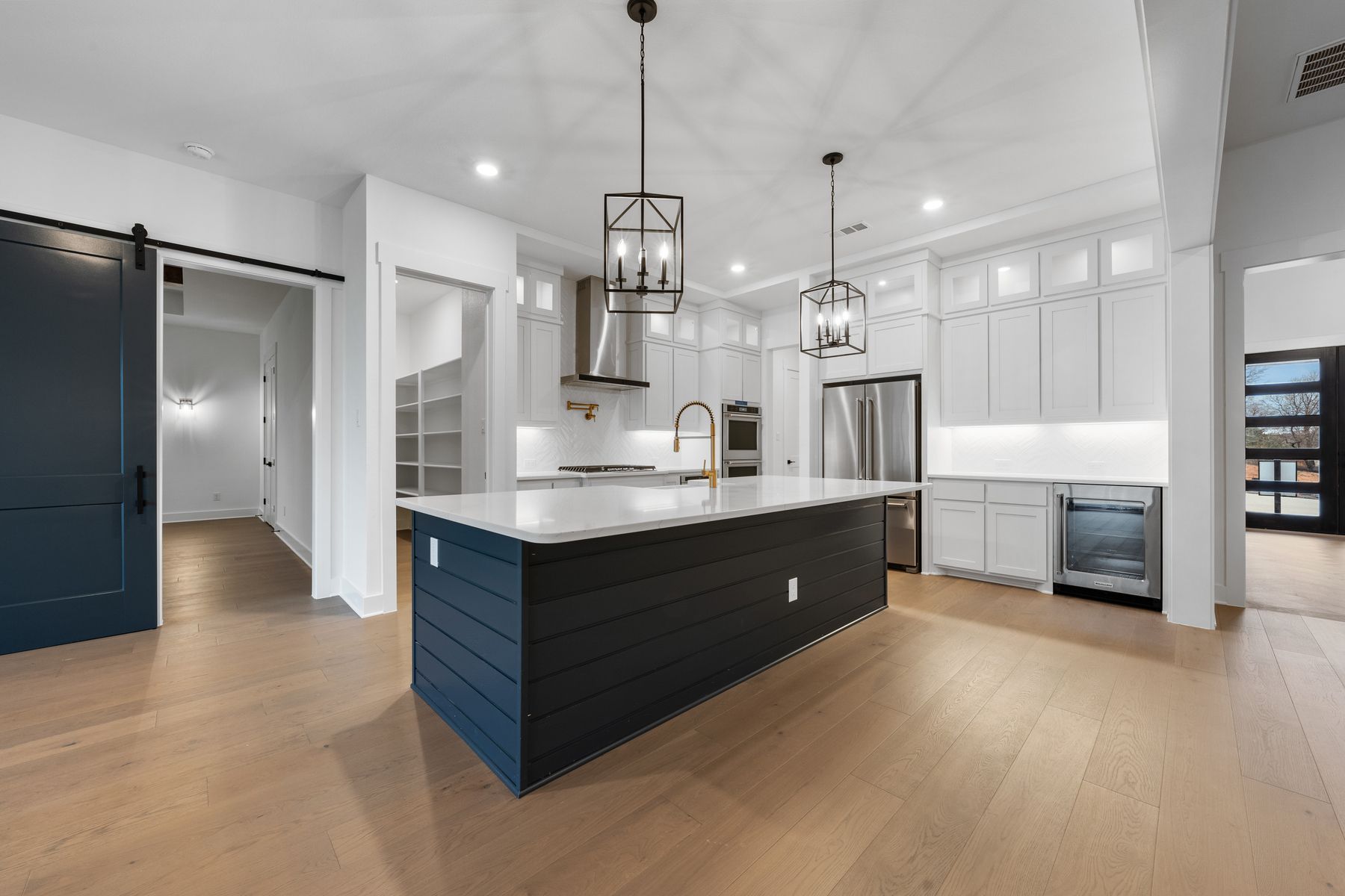 The kitchen has gorgeous white cabinetry with black hardware.