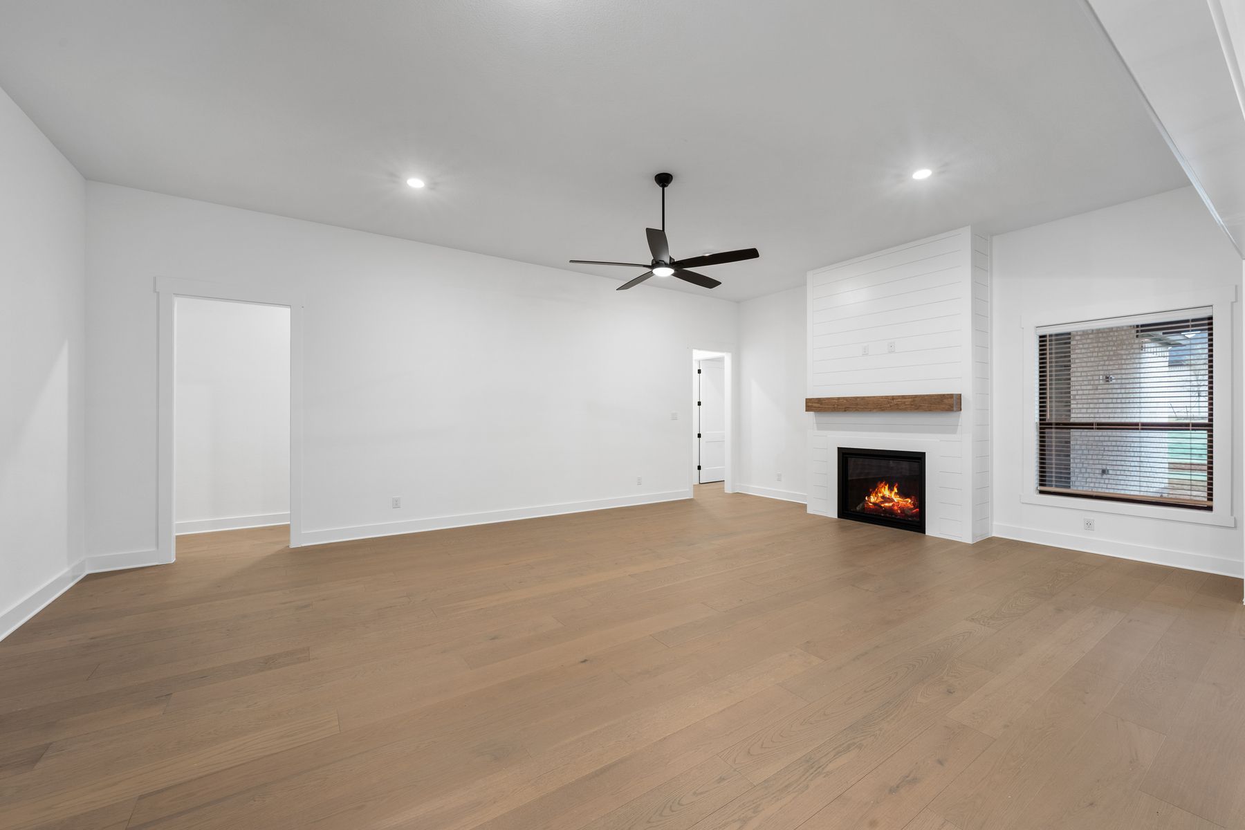 The spacious family room has large windows and an electric fireplace.