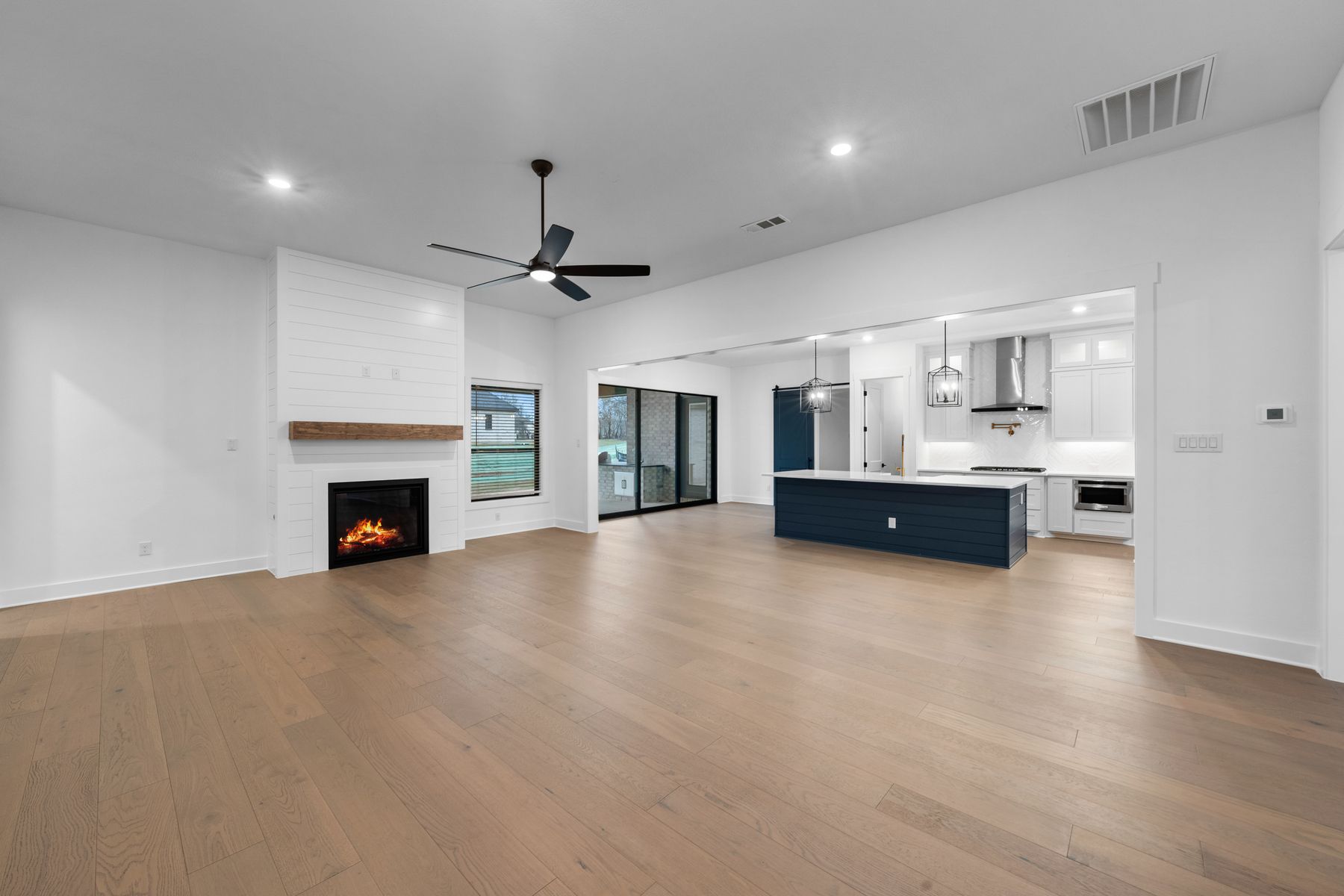 The spacious family room has large windows and an electric fireplace.