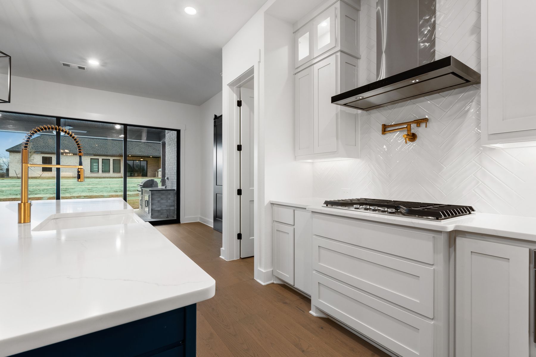 The kitchen has a beautiful blue island with quartz countertops.