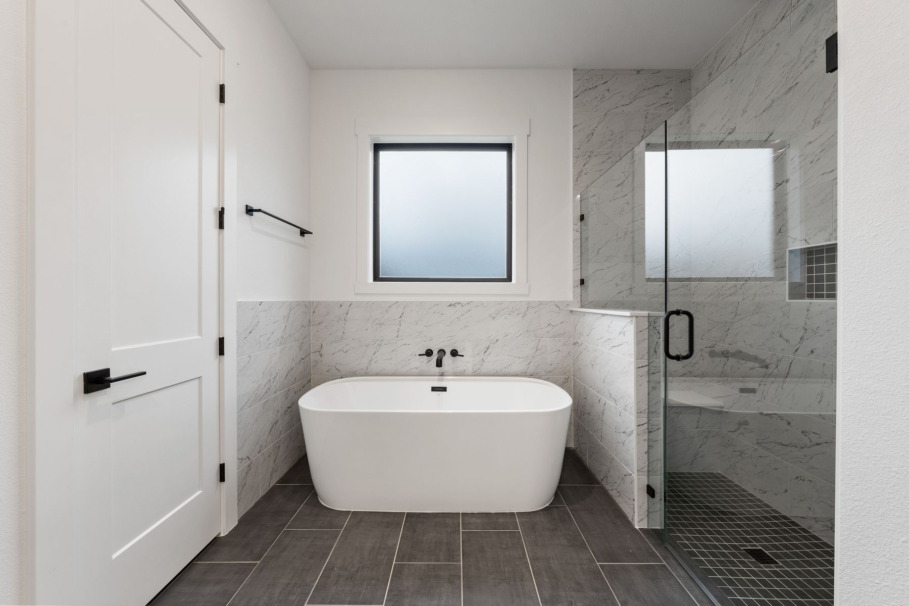 The gorgeous master bathroom has a large glass, walk-in shower and tub.