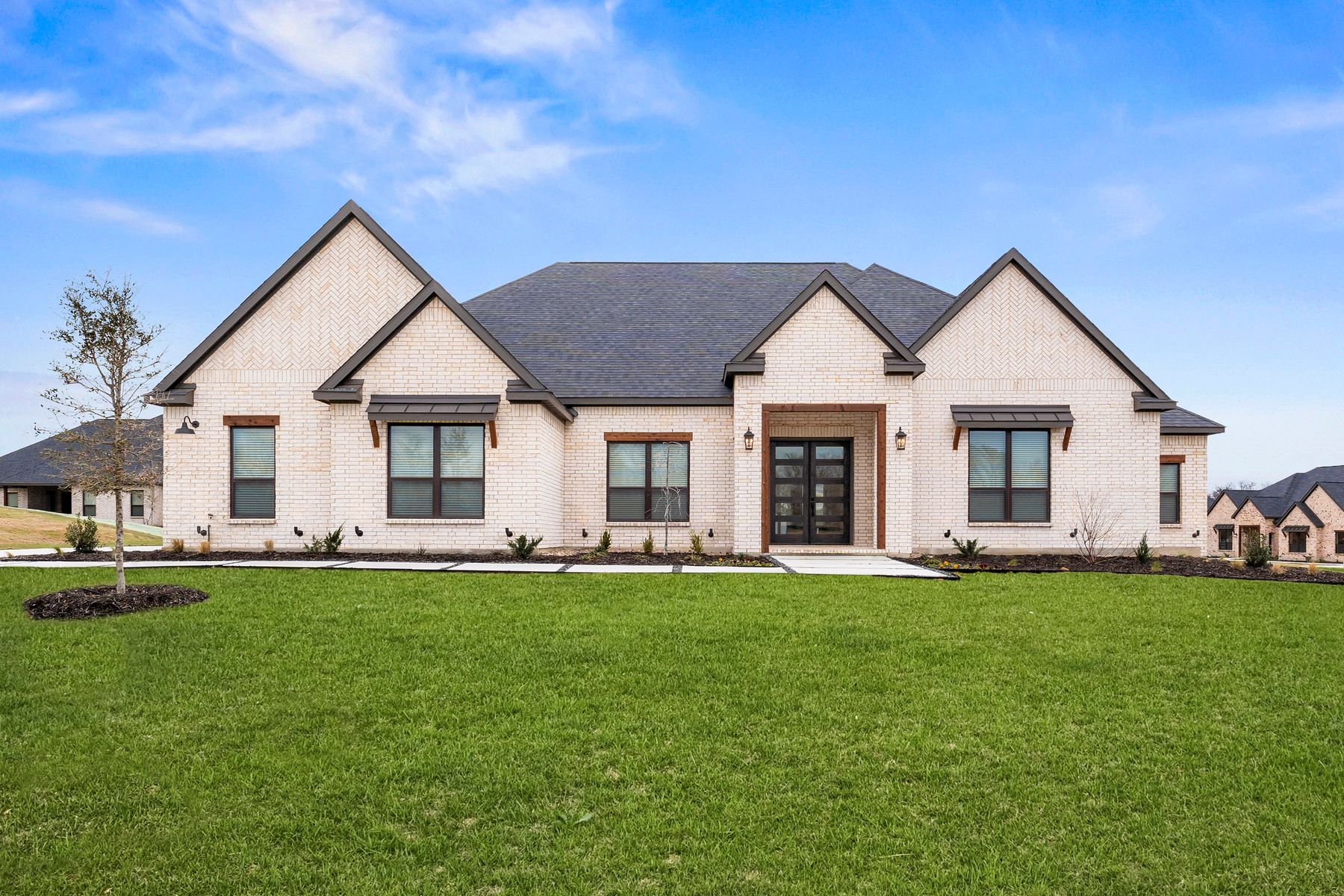 The Mantle II is a beautiful, one-story brick home with wood accents.