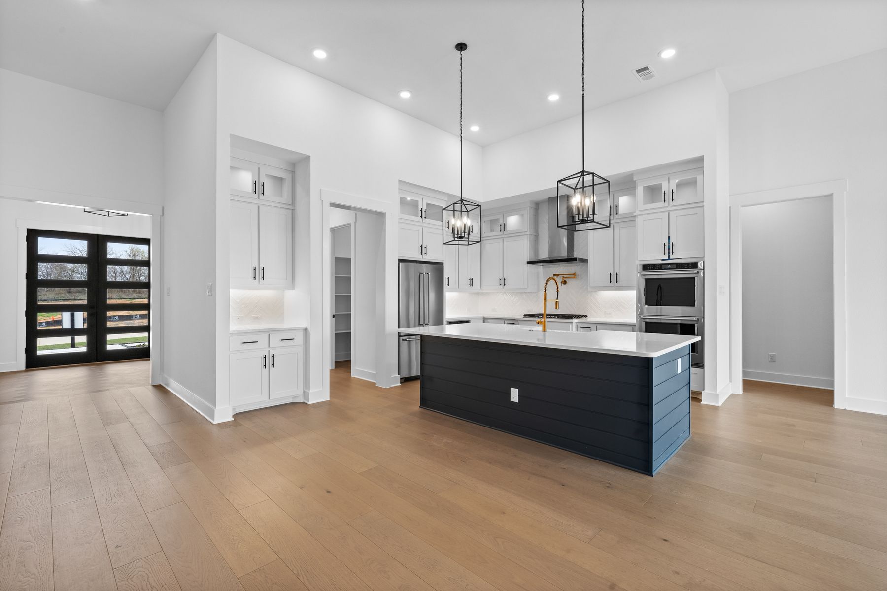 The kitchen has gorgeous white cabinetry with black hardware.