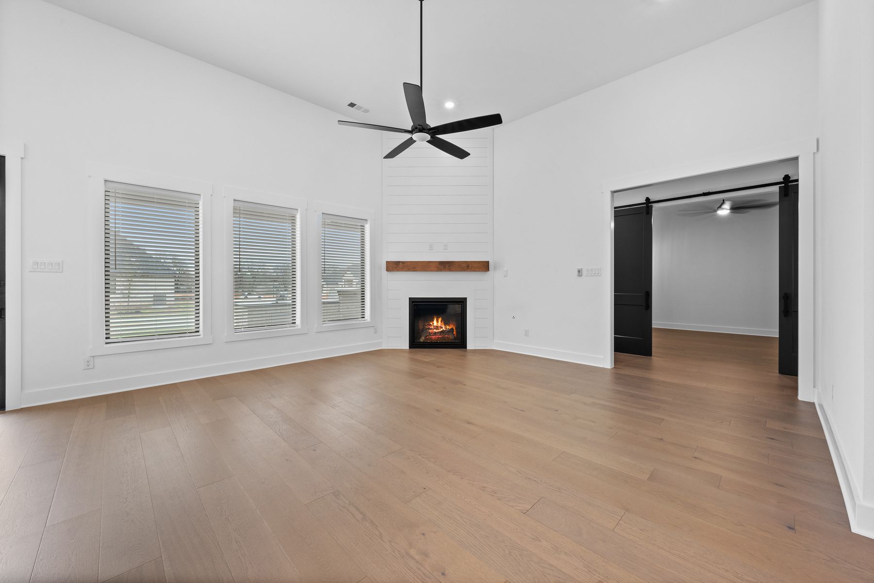 The spacious family room has large windows and an electric fireplace.