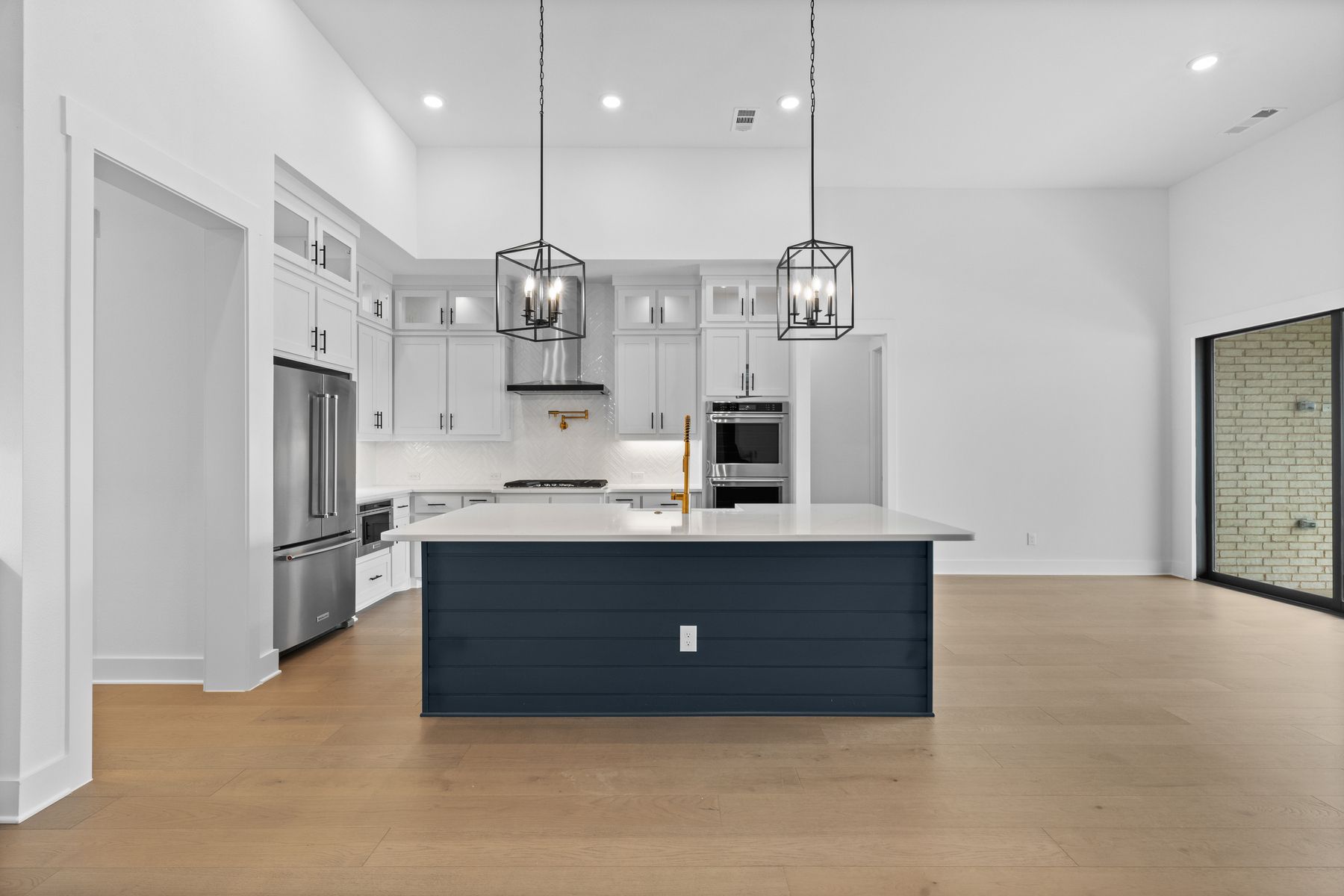 The kitchen has a beautiful blue island with quartz countertops.