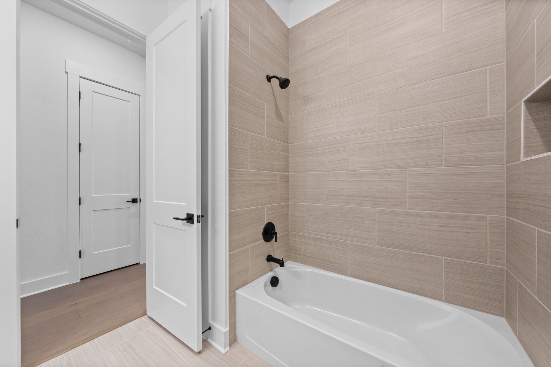 The secondary bathroom has a large, tiled  shower-tub combo.