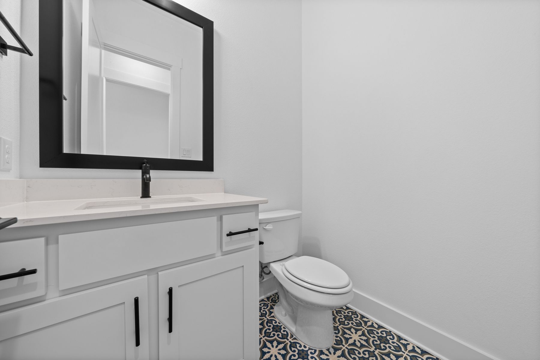 The half bathroom has gorgeous tile flooring.