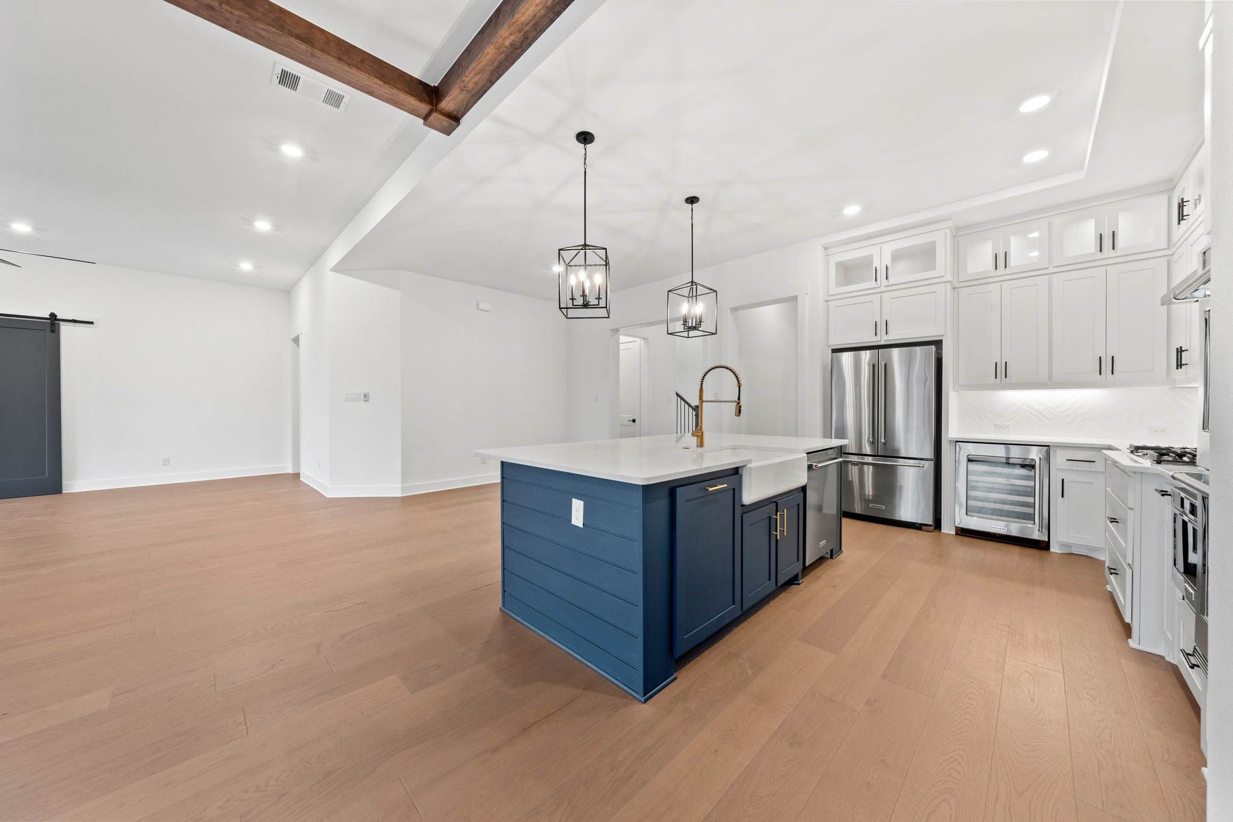 The kitchen has a beautiful blue island with quartz countertops.