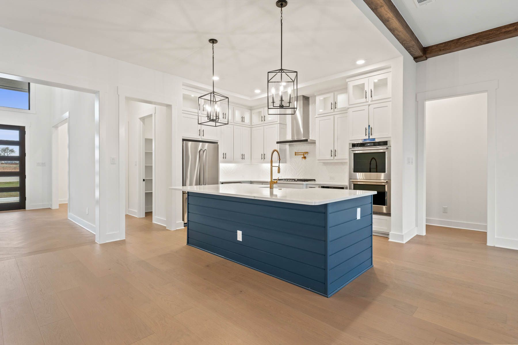 The kitchen has a beautiful blue island with quartz countertops.