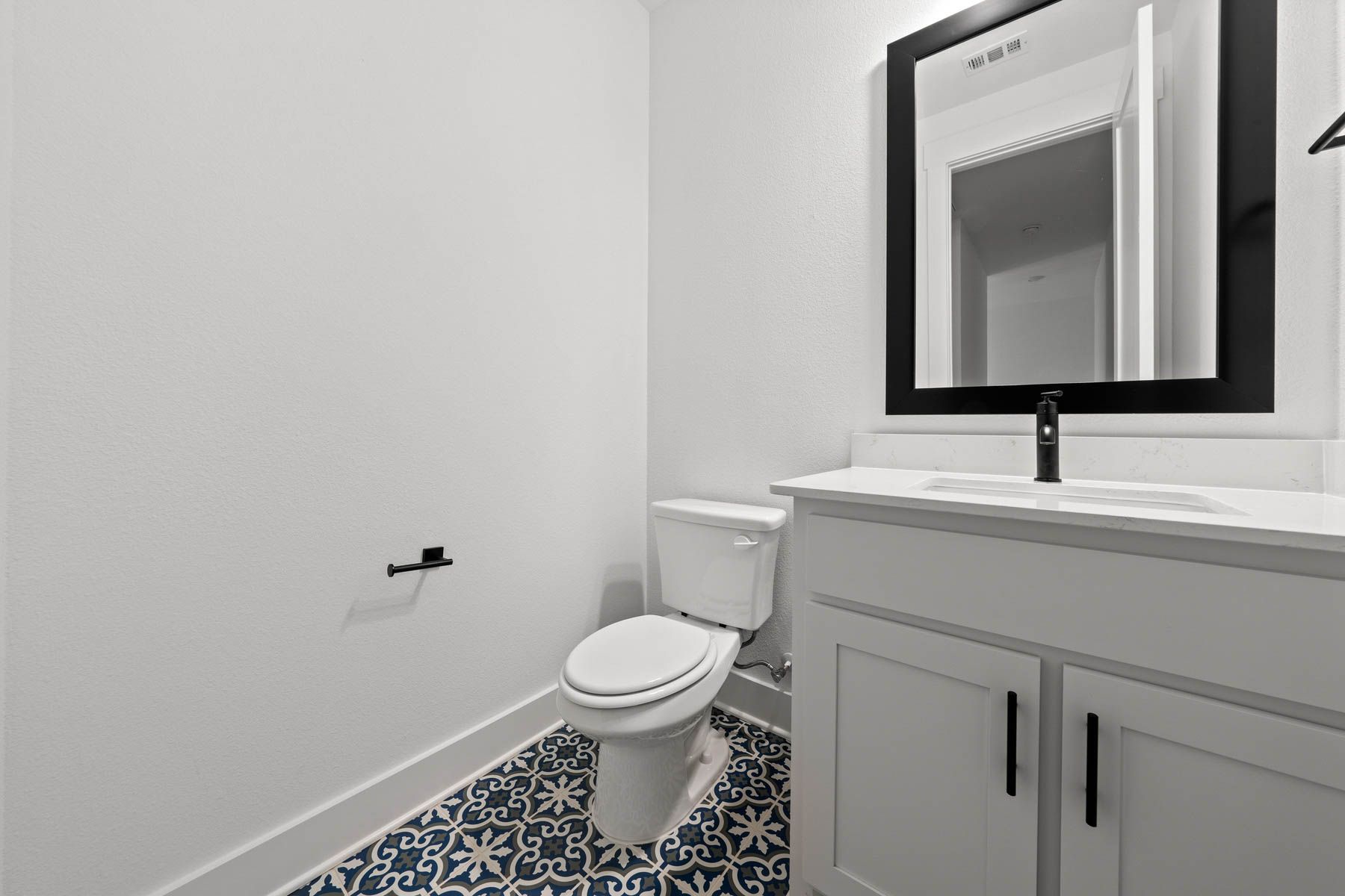 The half bathroom has gorgeous tile flooring.
