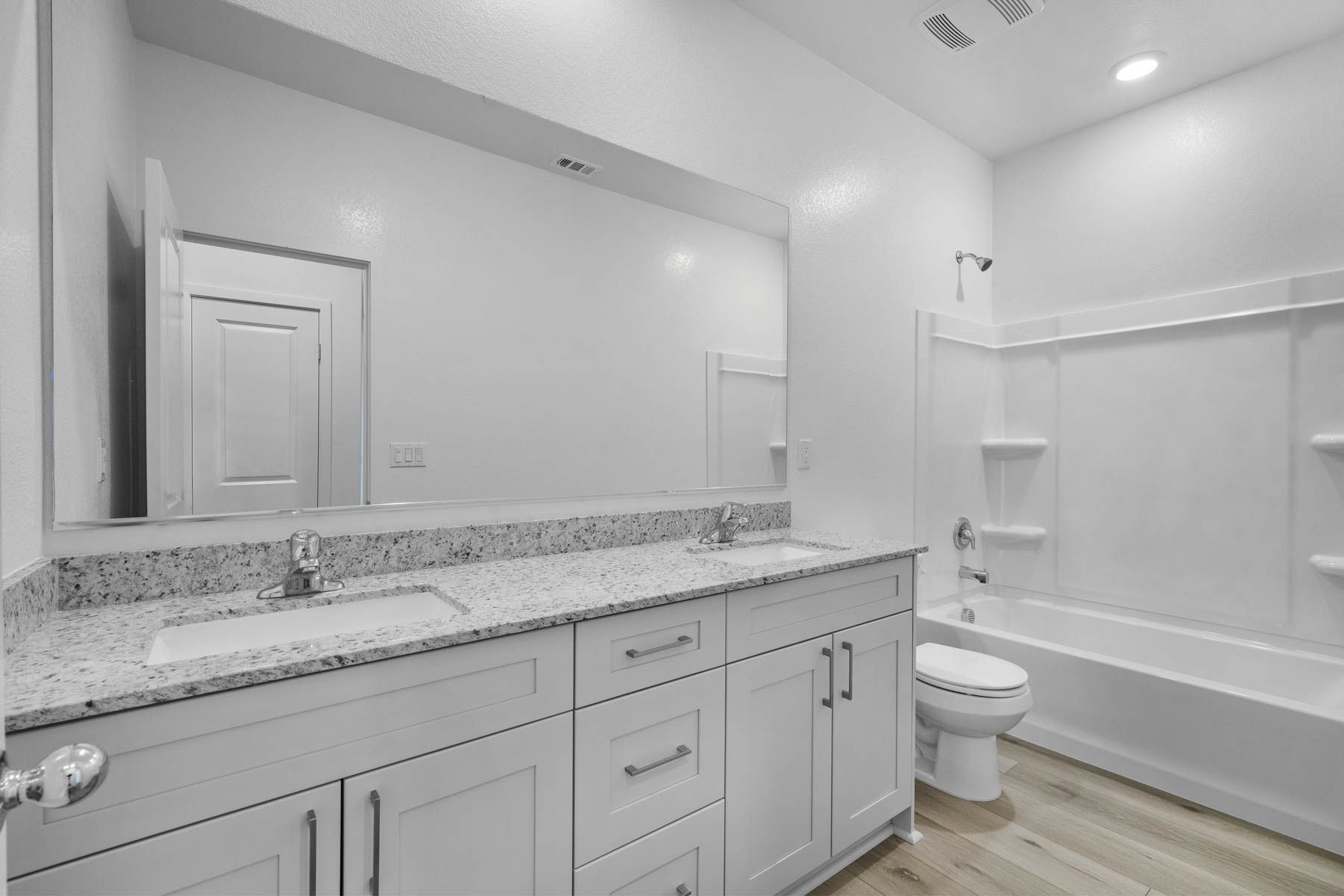 The secondary bathroom has a dual sink vanity and tub/shower combo.