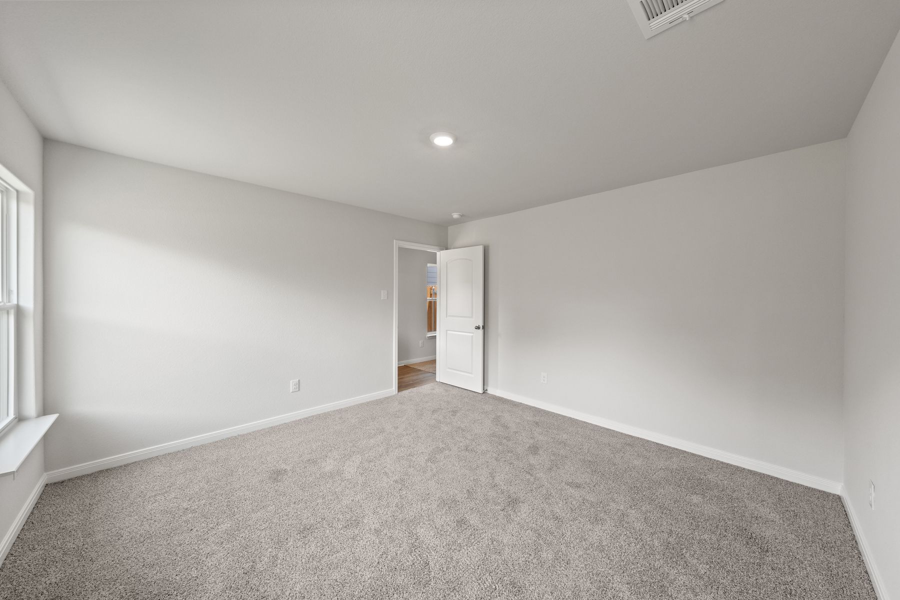 The spacious master bedroom of the Cedar has a large window that lets in great, natural light.