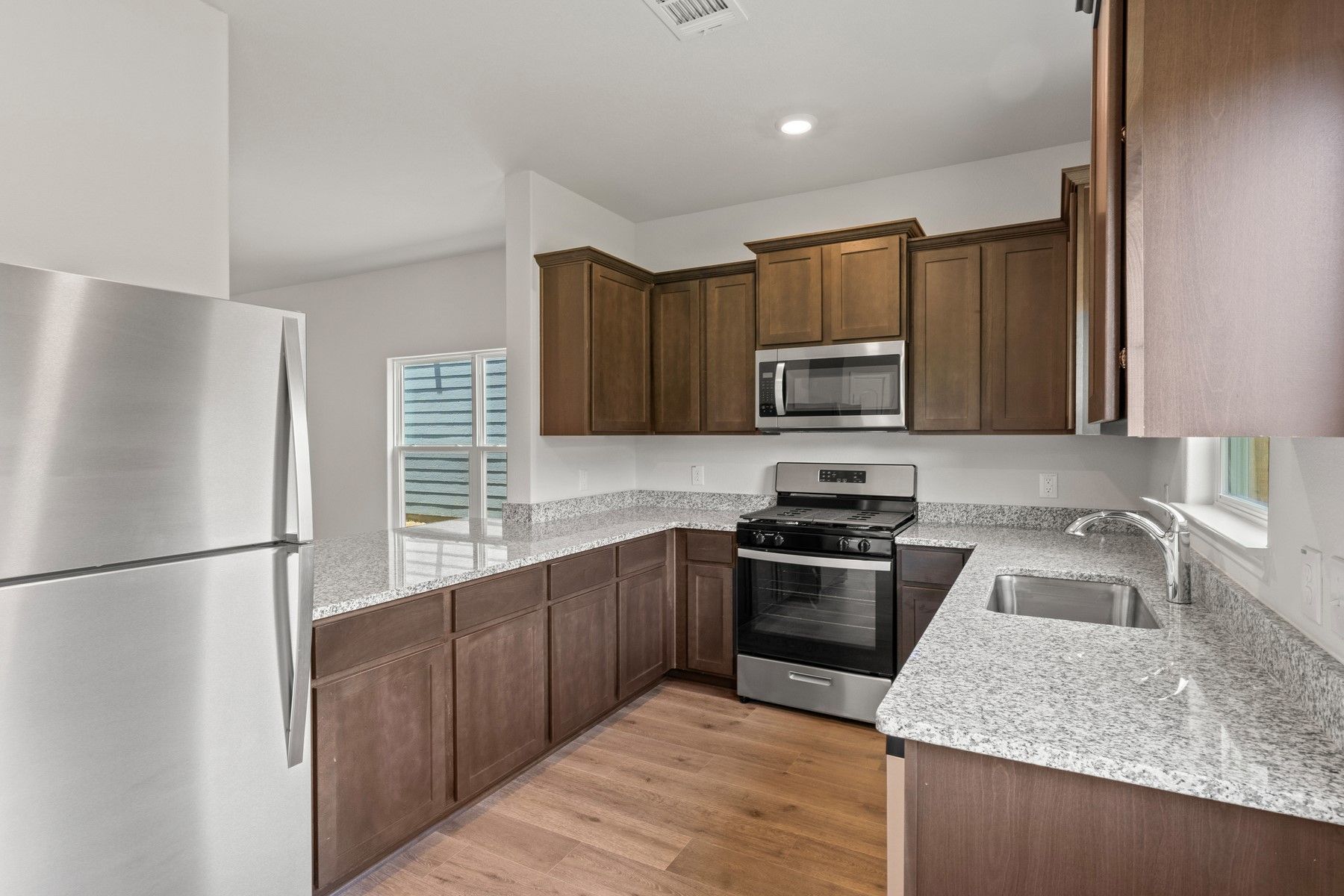 The kitchen of the Piper has gorgeous wood cabinetry and sprawling granite countertops.