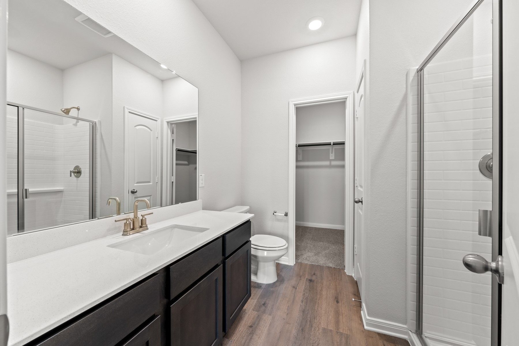 The master bathroom of the Piper has a large vanity space and glass, walk-in shower.