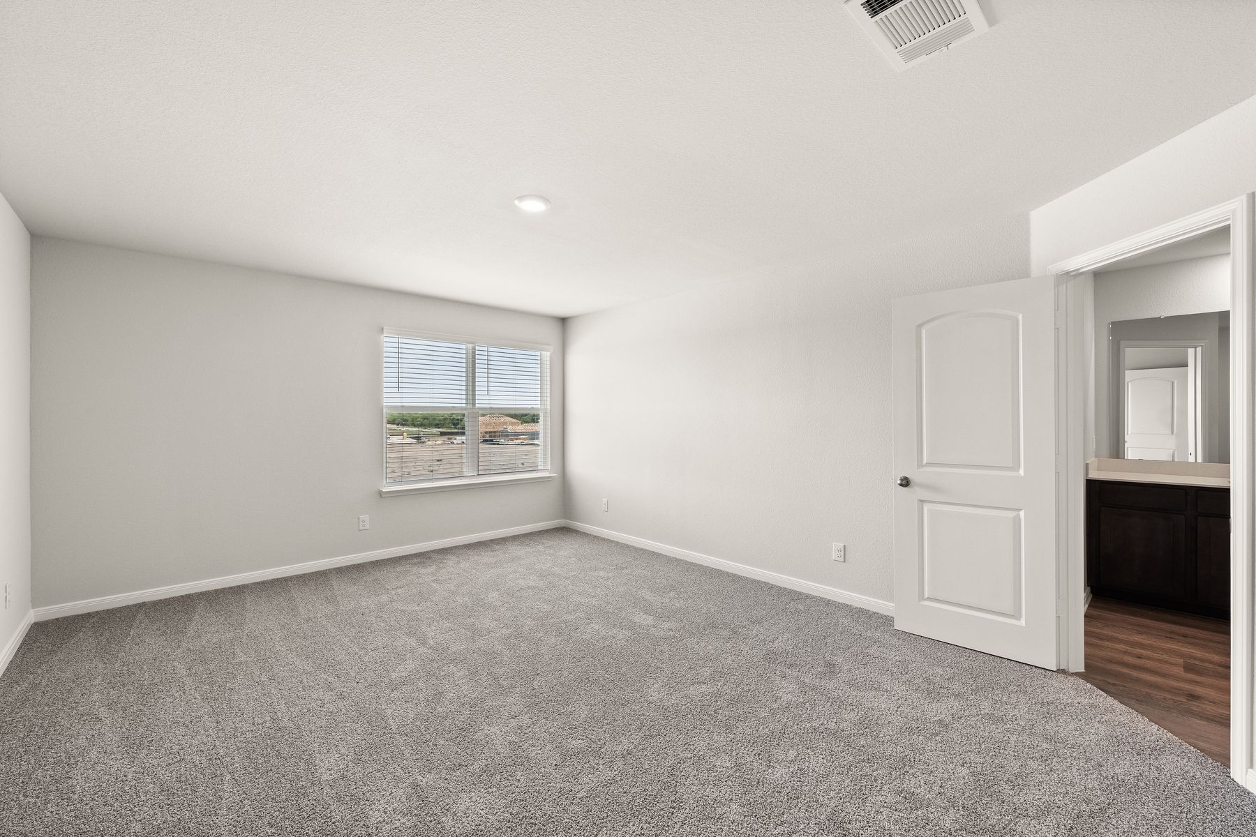 The master bedroom of the Rayburn is spacious and has a large window that lets in great, natural light.